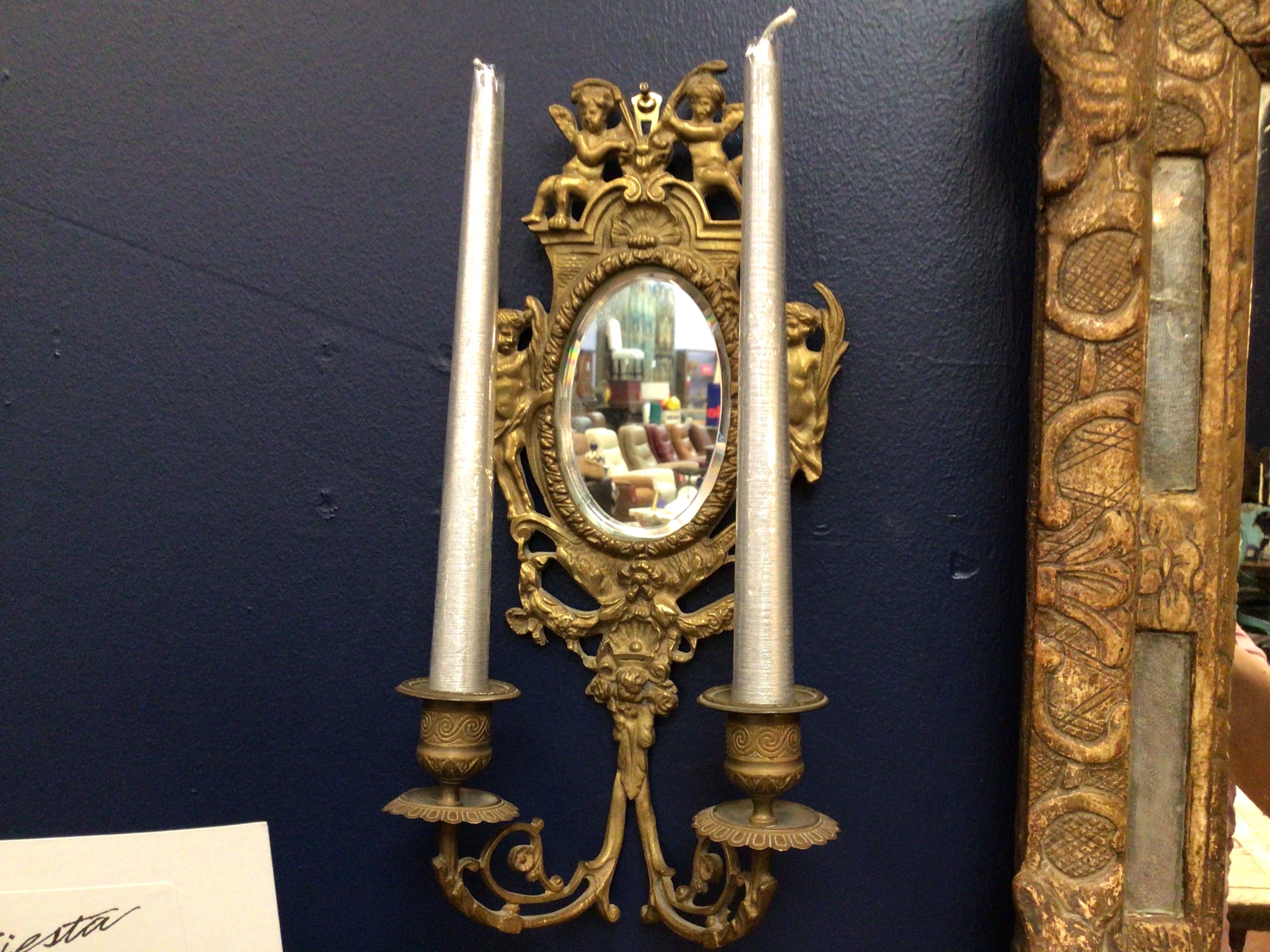 Decorative wall sconce with candles on a dark blue wall
