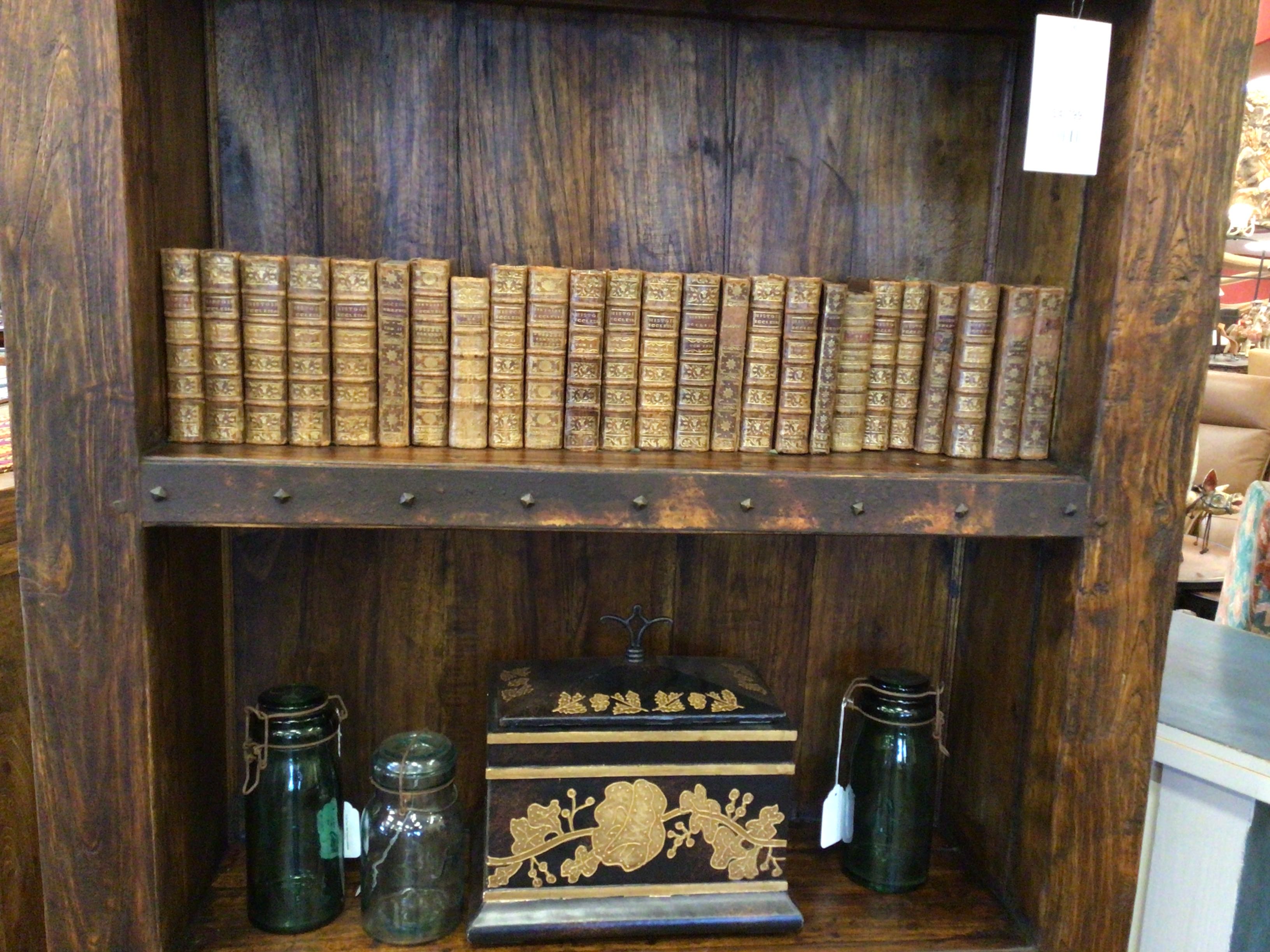 Wooden shelf with antique books and decorative items