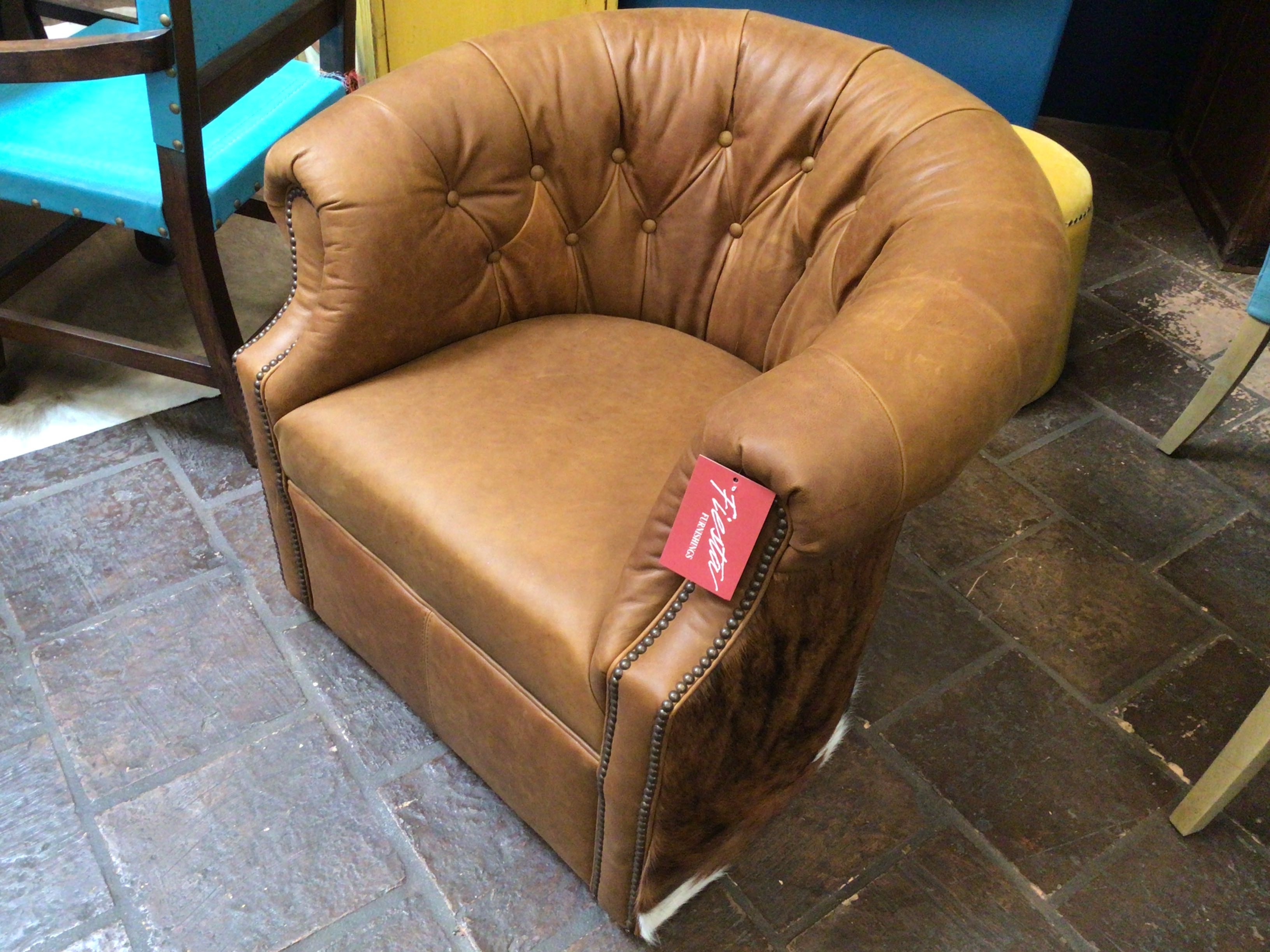 Brown leather armchair with a red tag on a stone floor