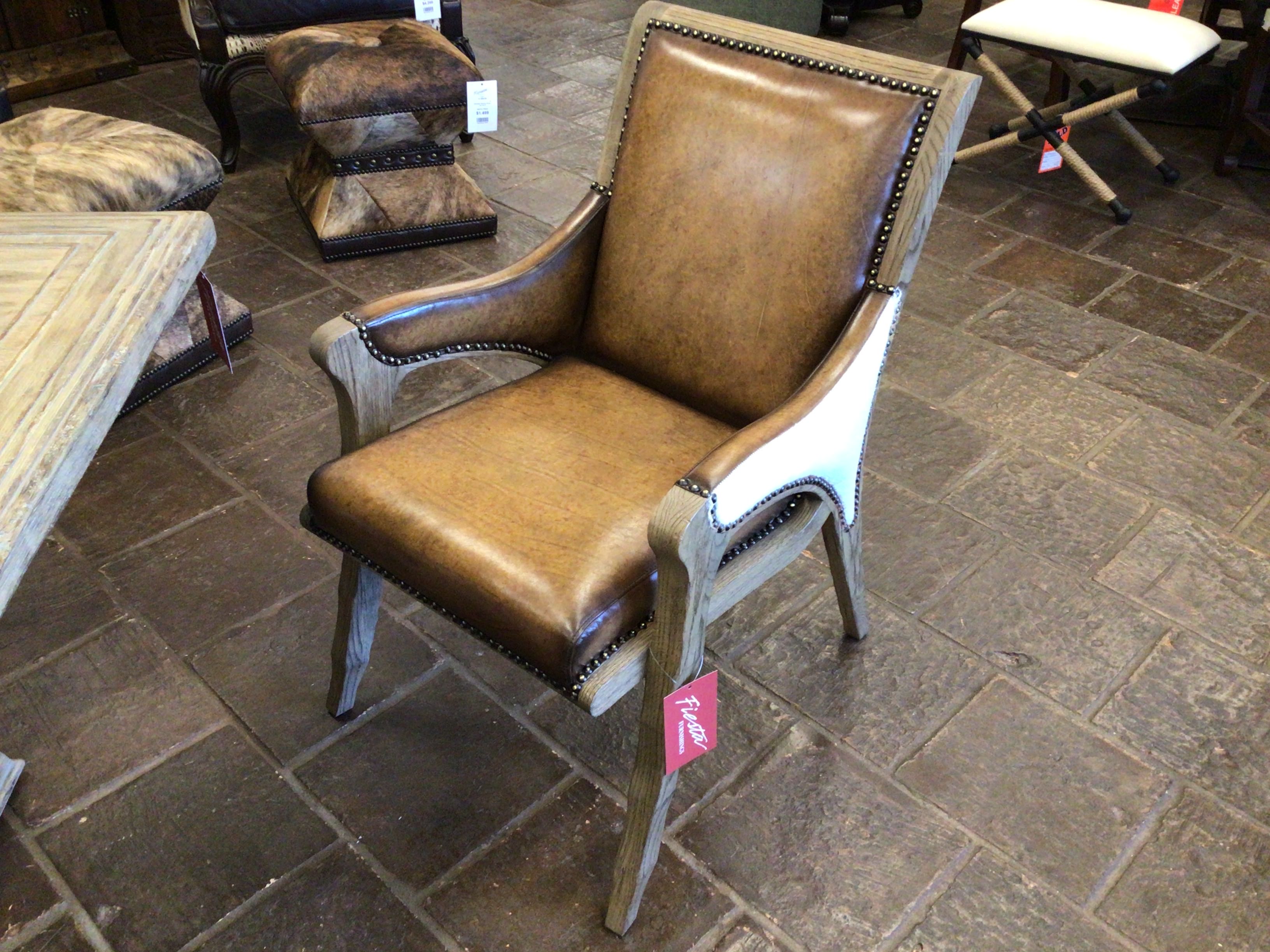 Brown leather chair with carved wood frame on a stone floor