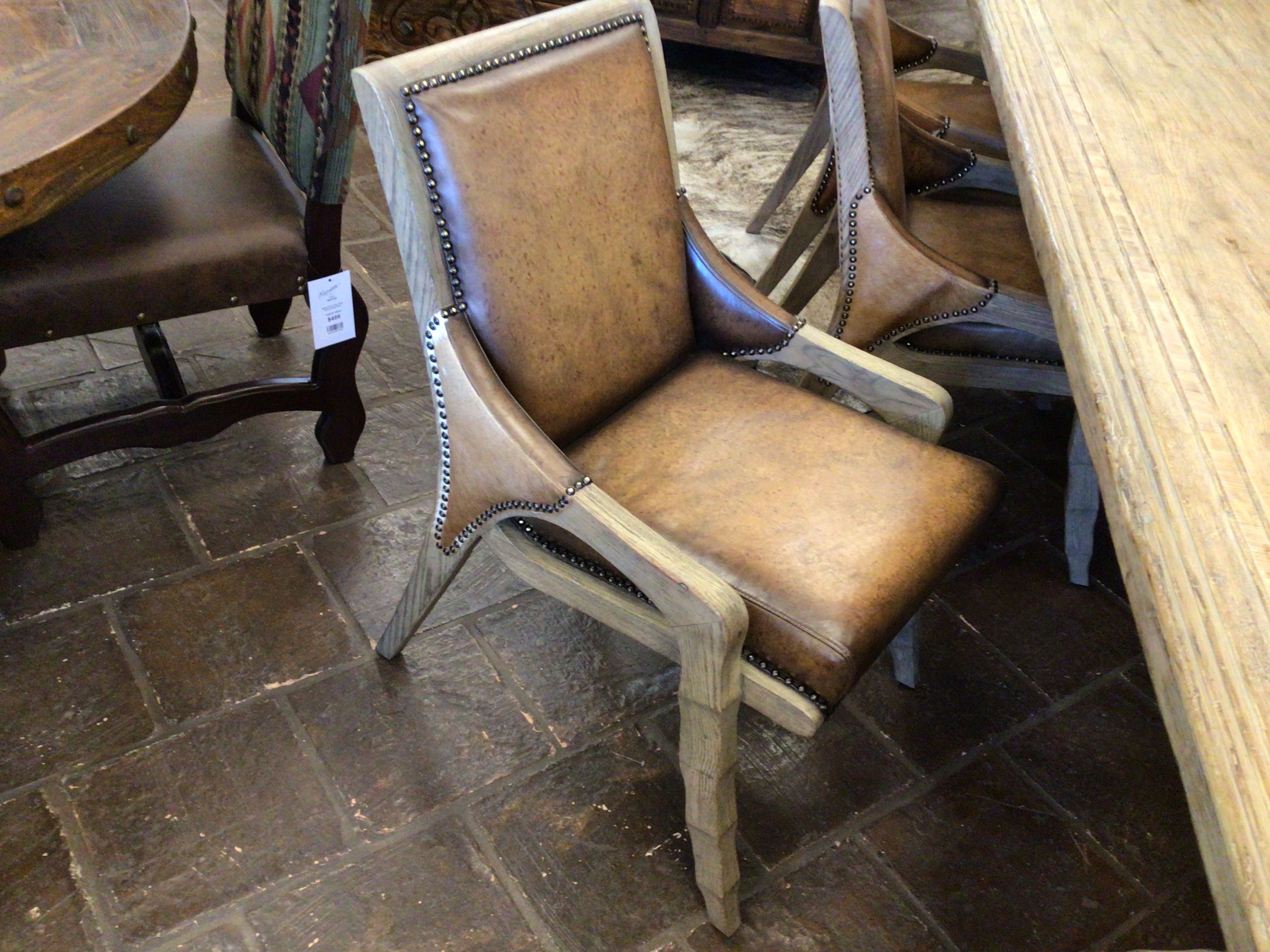 Brown leather chair with wooden frame on a stone floor