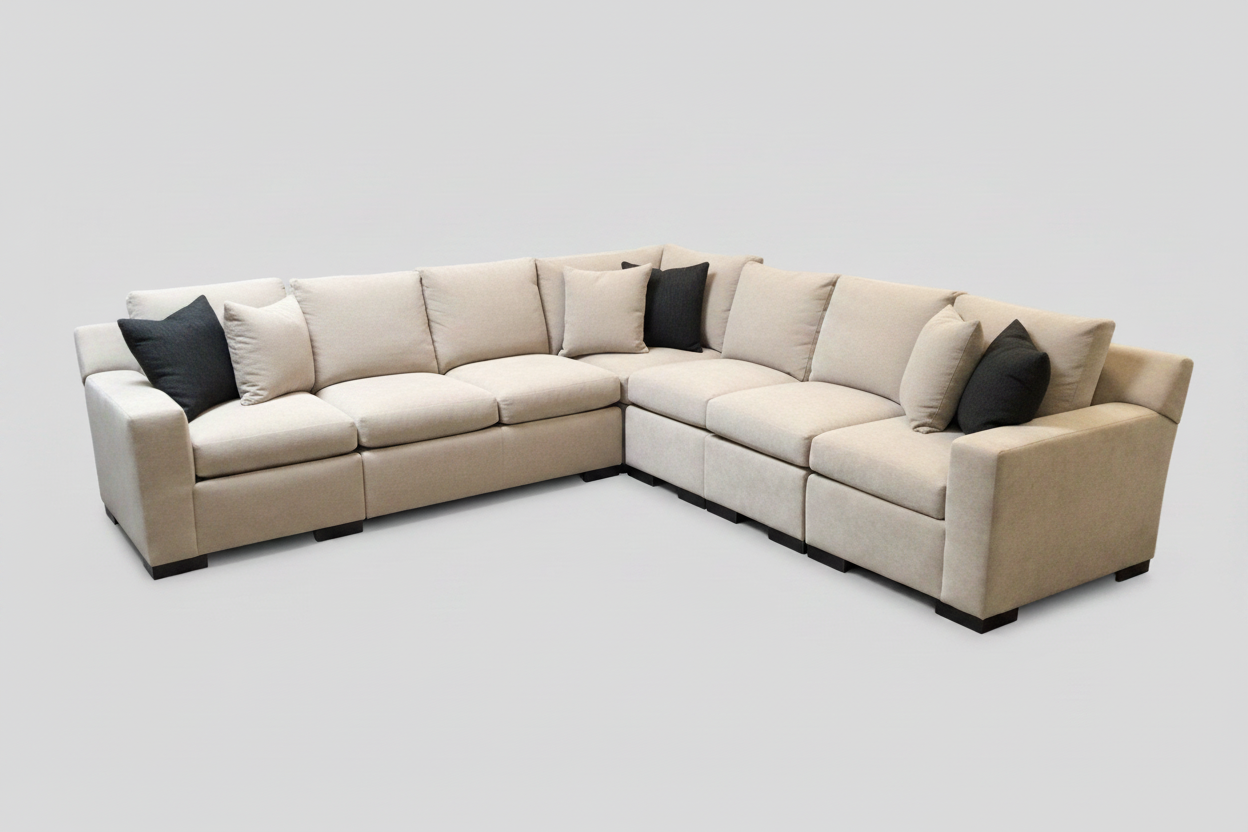 Beige sectional sofa with black cushions on a light gray background