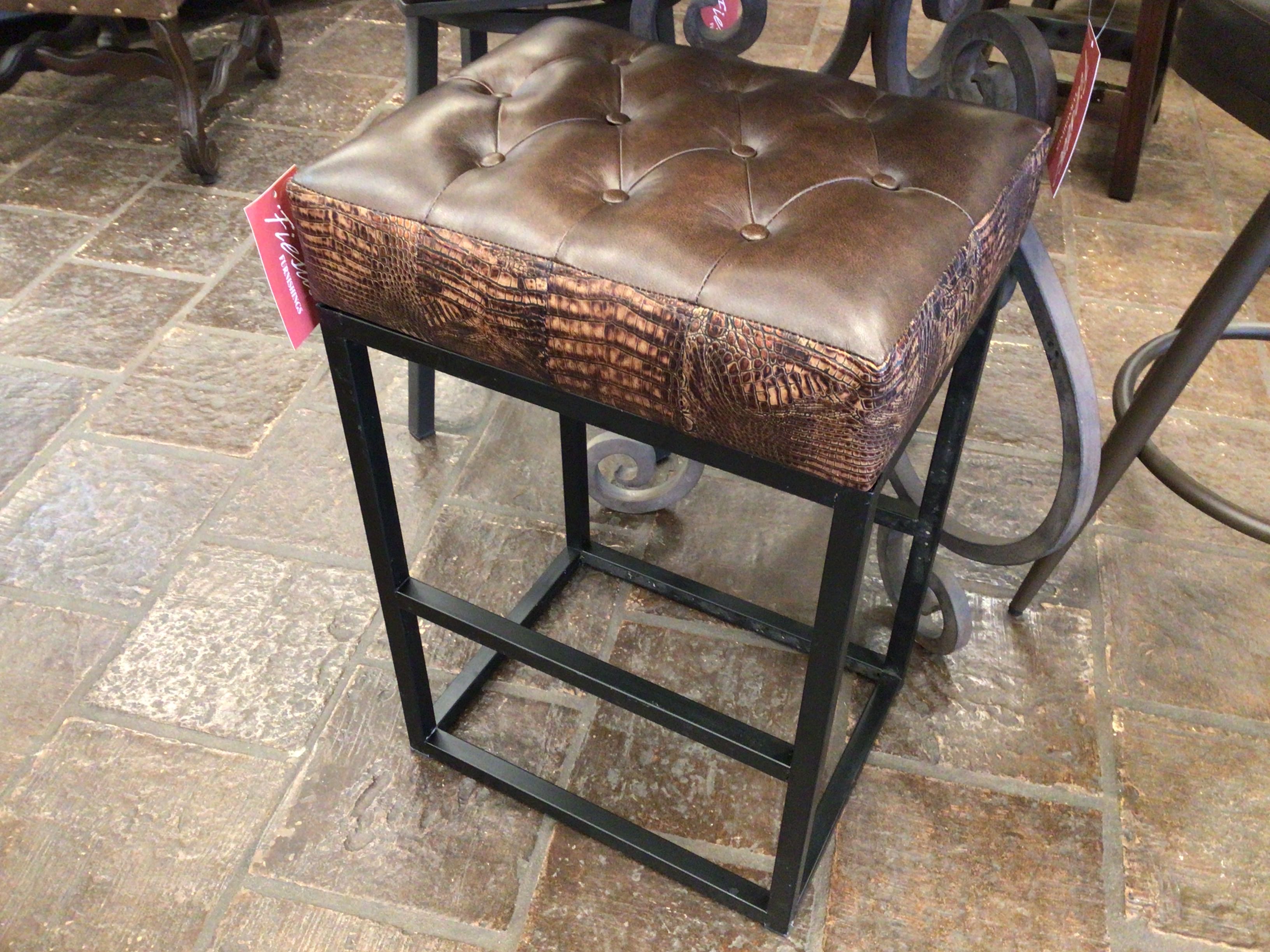 Brown leather bar stool with metal frame on a stone floor