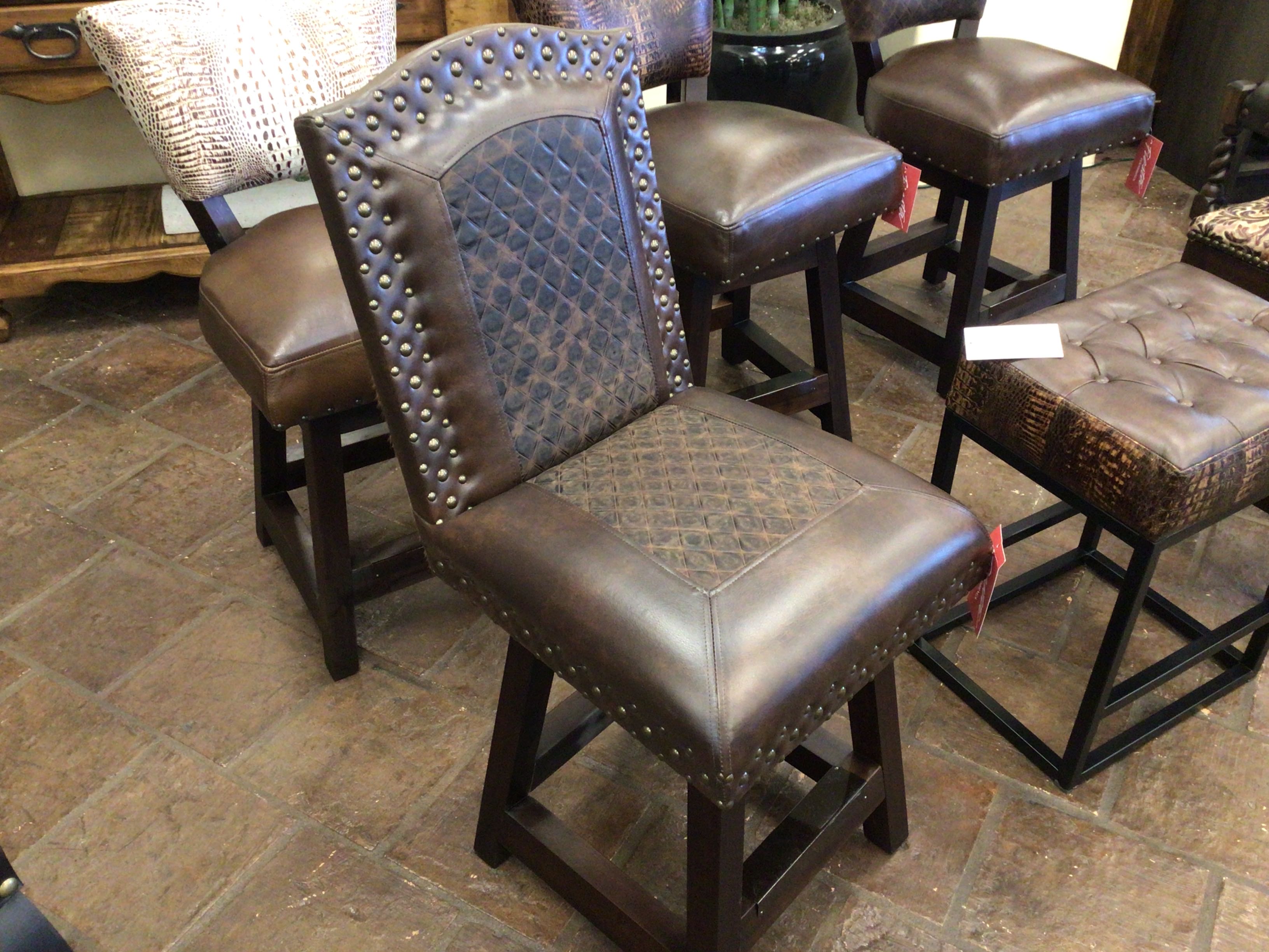 Brown leather bar stools with studded details on a stone floor.