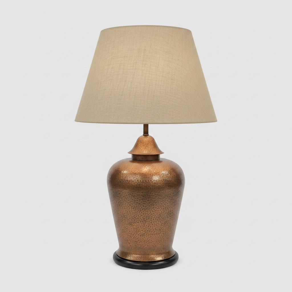 Bronze table lamp with a beige lampshade on a light gray background at Fiesta Furnishings in Scottsdale
