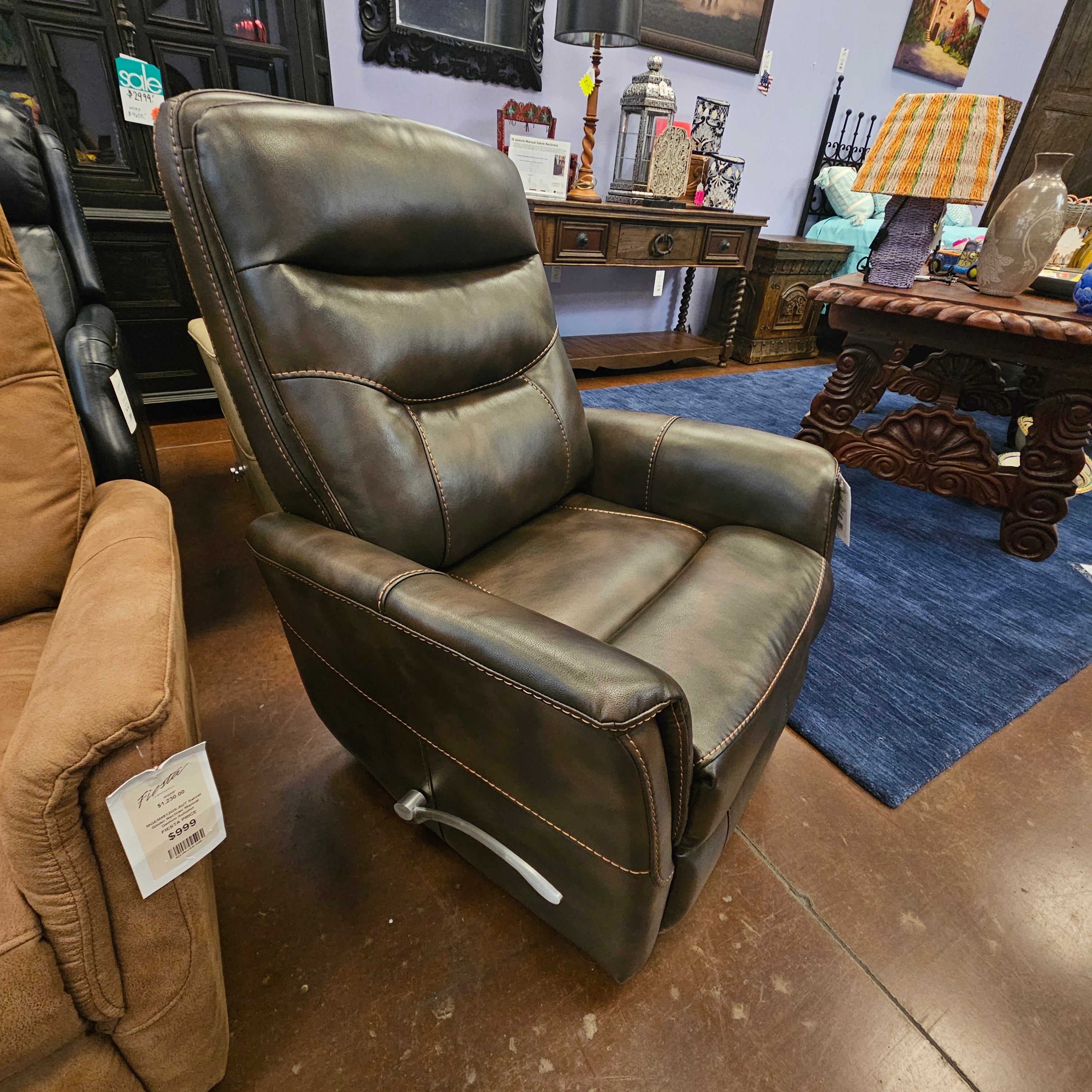 Brown leather recliner chair in a showroom setting with a table and decor items in the background.