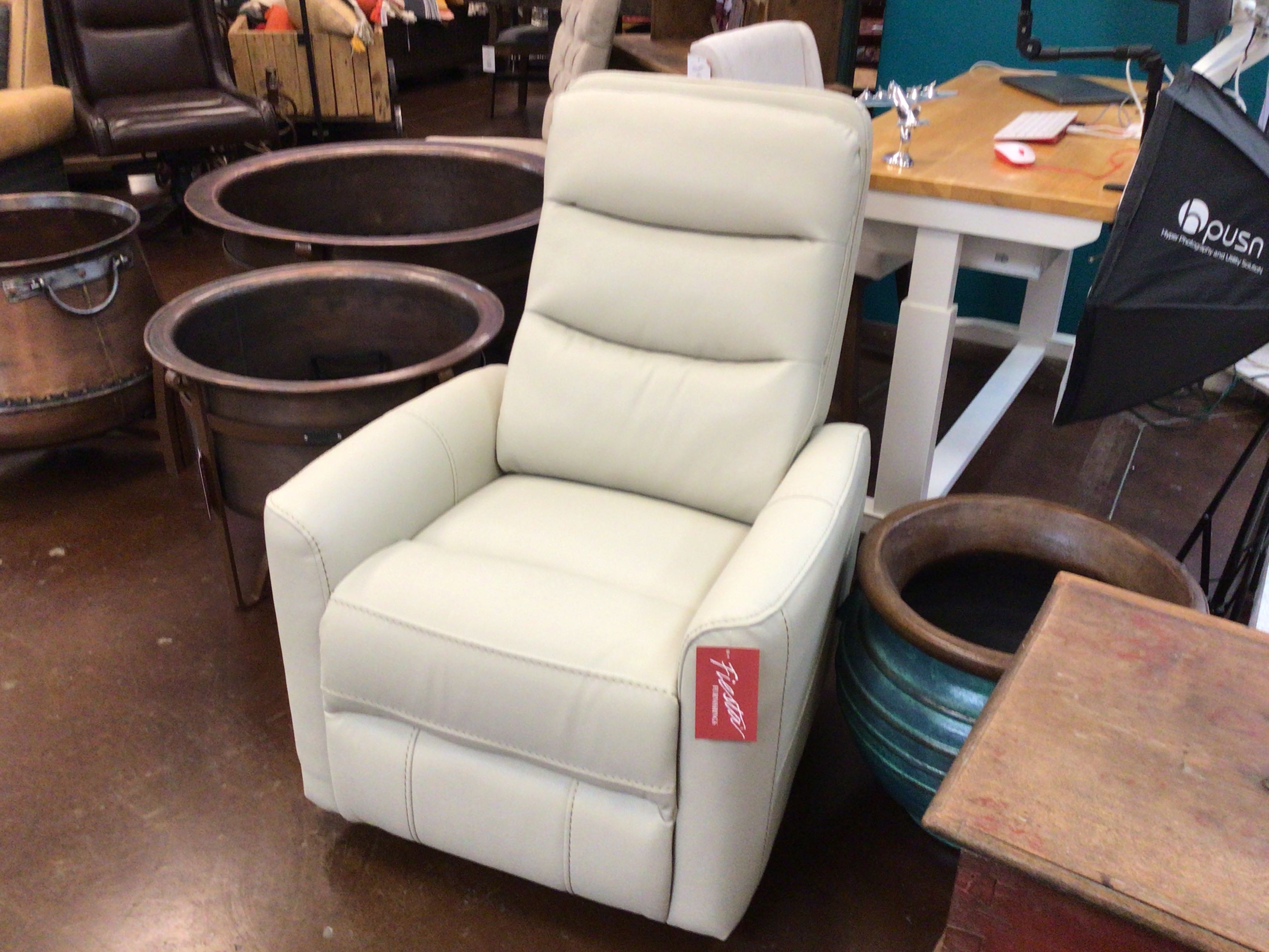White recliner chair with a visible brand tag in an indoor setting with furniture and decor.