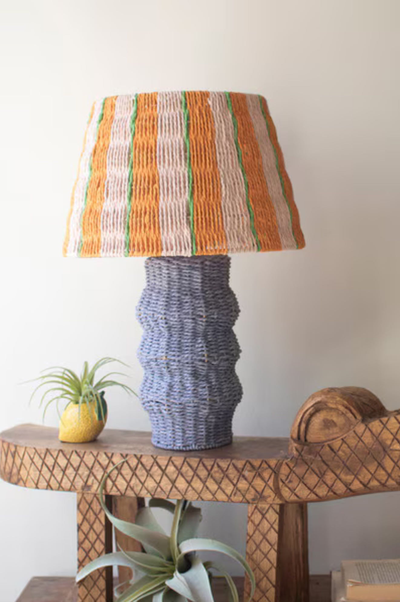 Decorative lamp with striped shade on a wooden table