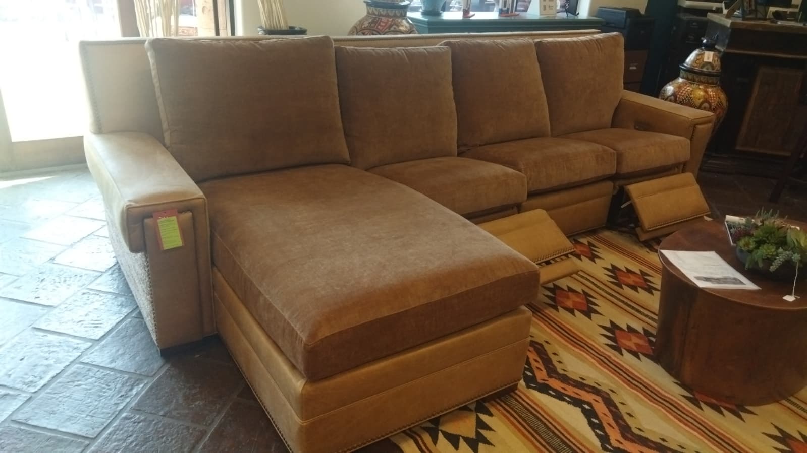 Brown sectional sofa in a room with a patterned rug and coffee table.