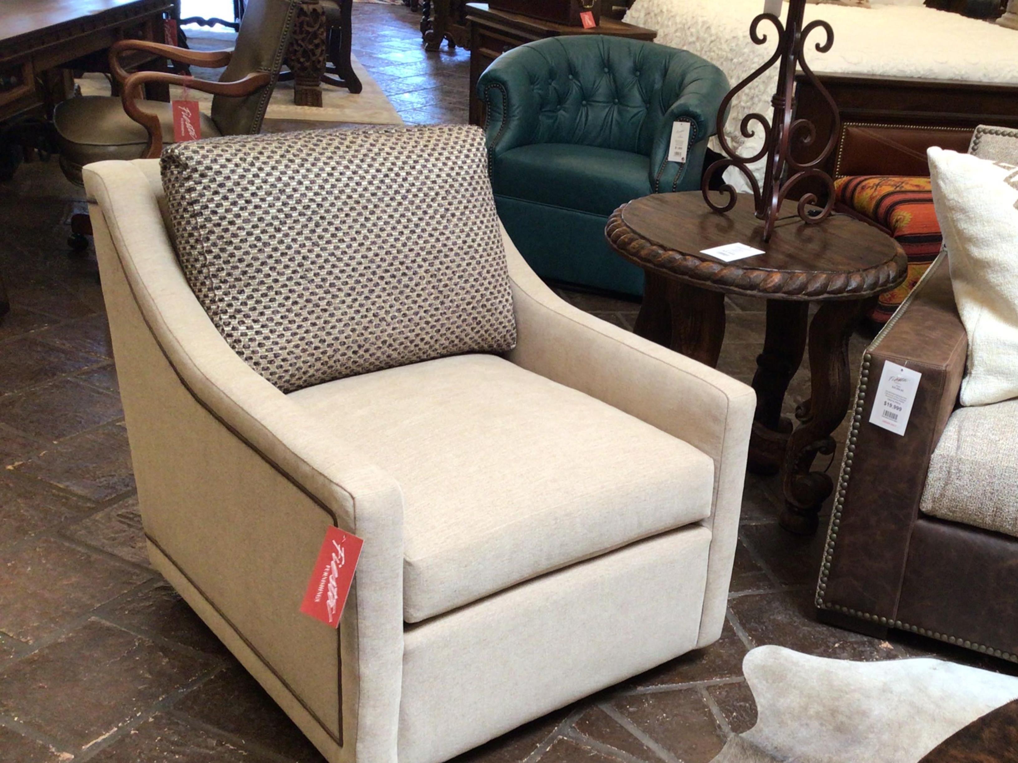 Beige armchair with a patterned pillow in a furniture store setting
