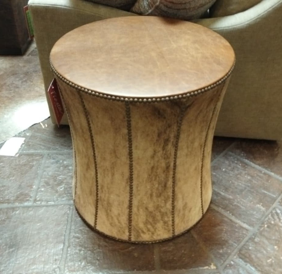 Round brown leather stool on a tiled floor