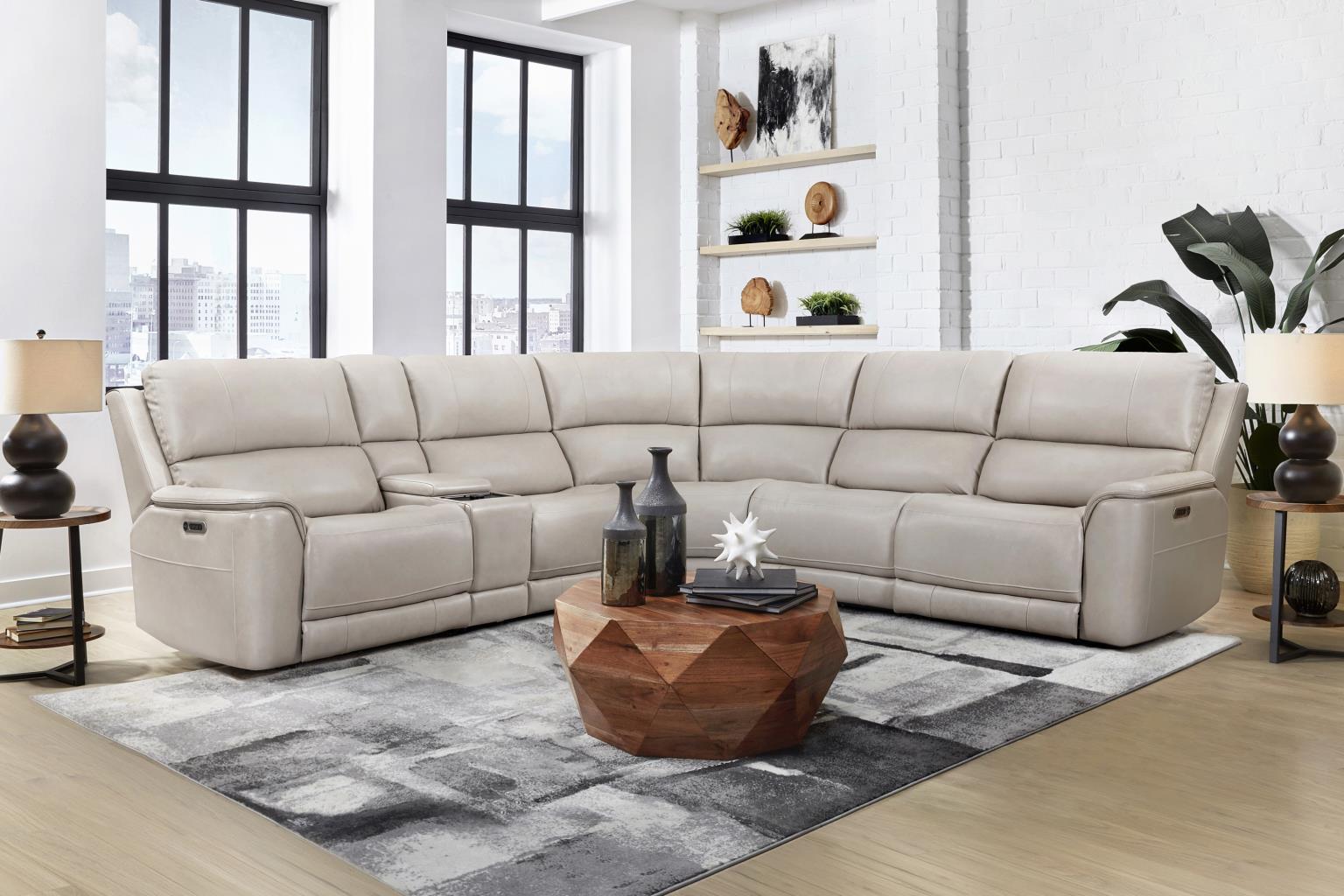 Beige sectional sofa in a modern living room with a coffee table and decor items.