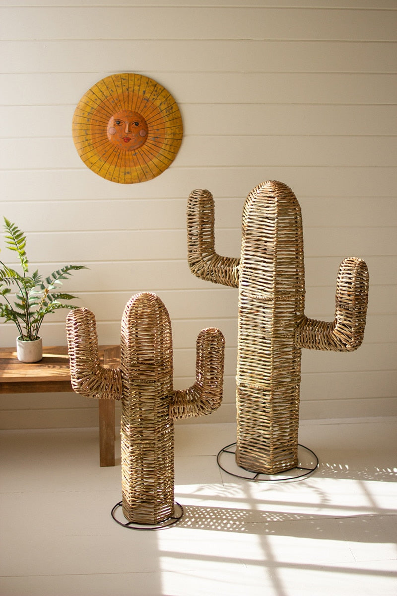 Woven cactus sculptures in a room with a wooden table and wall art.