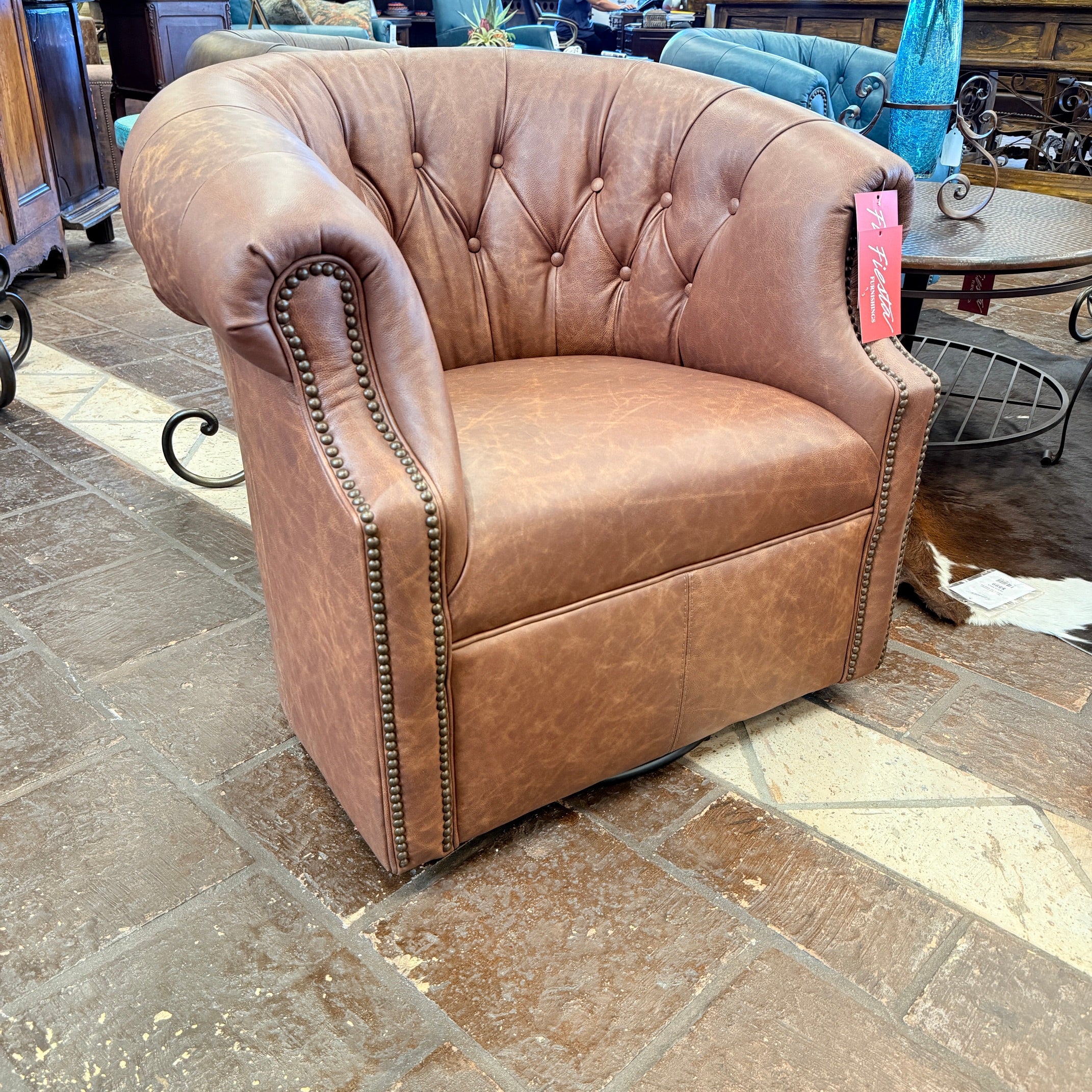 Brown leather armchair with tufted backrest on a stone floor
