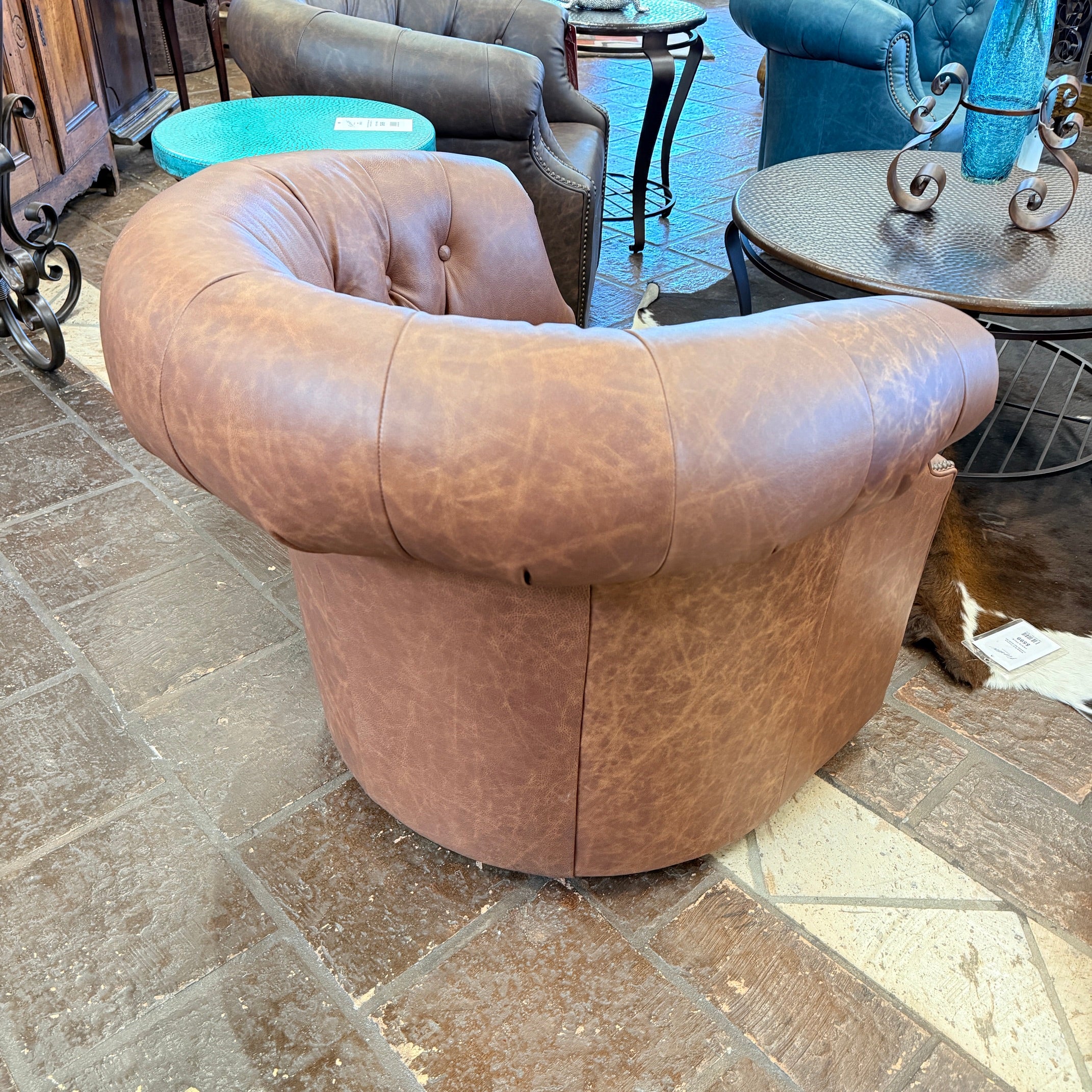Brown leather chair on a tiled floor with other furniture in the background