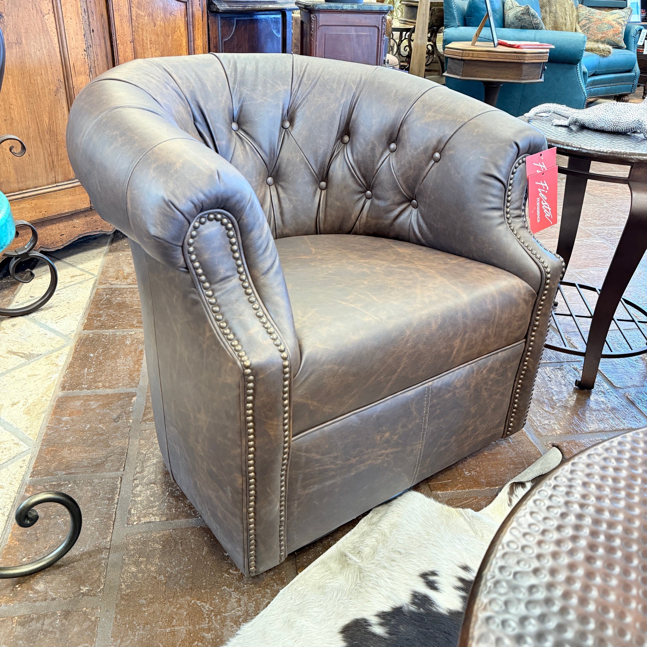 Brown leather armchair with tufted backrest in a furniture store setting