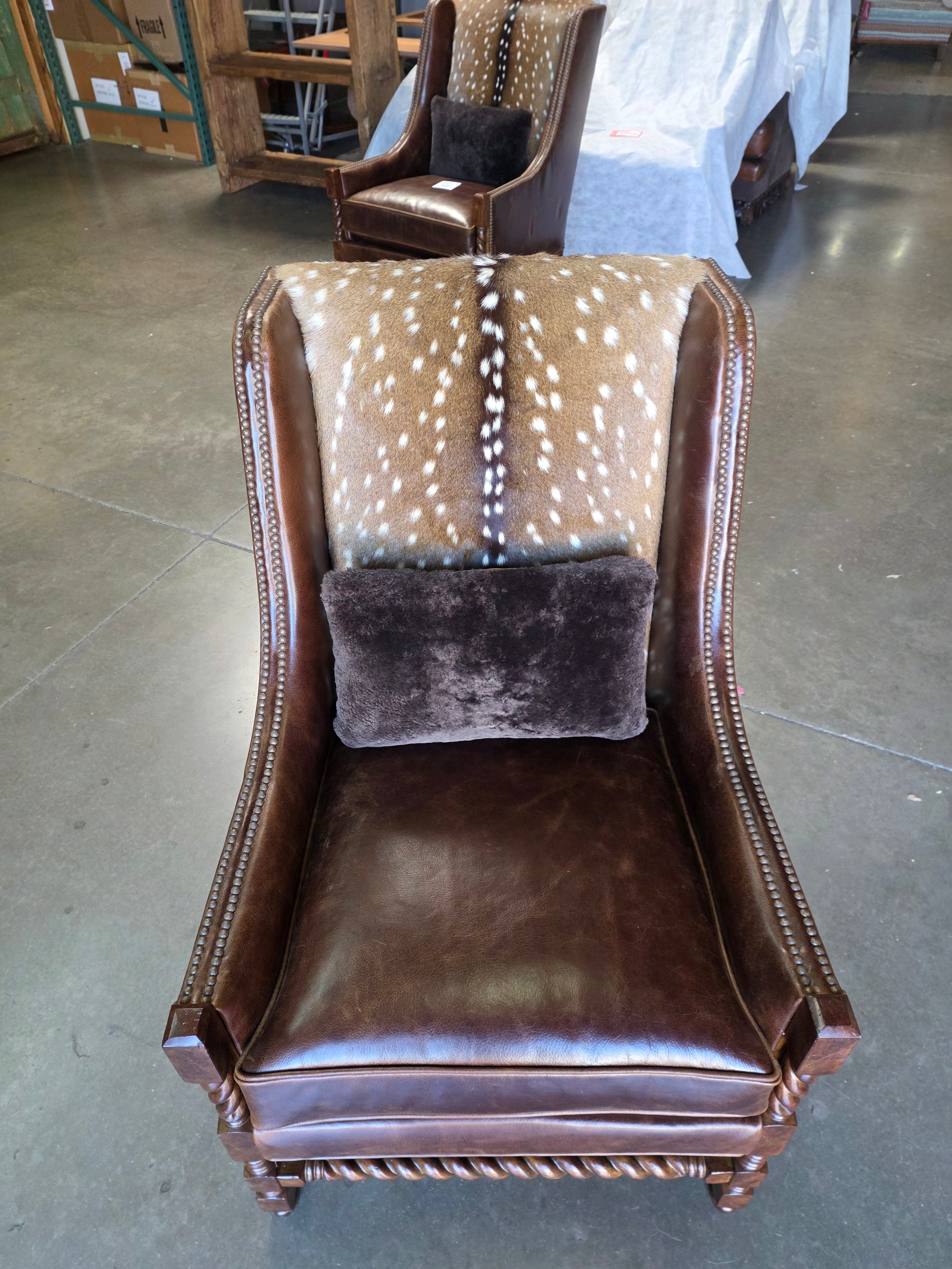Brown leather bag with a deer patterned pillow on a concrete floor