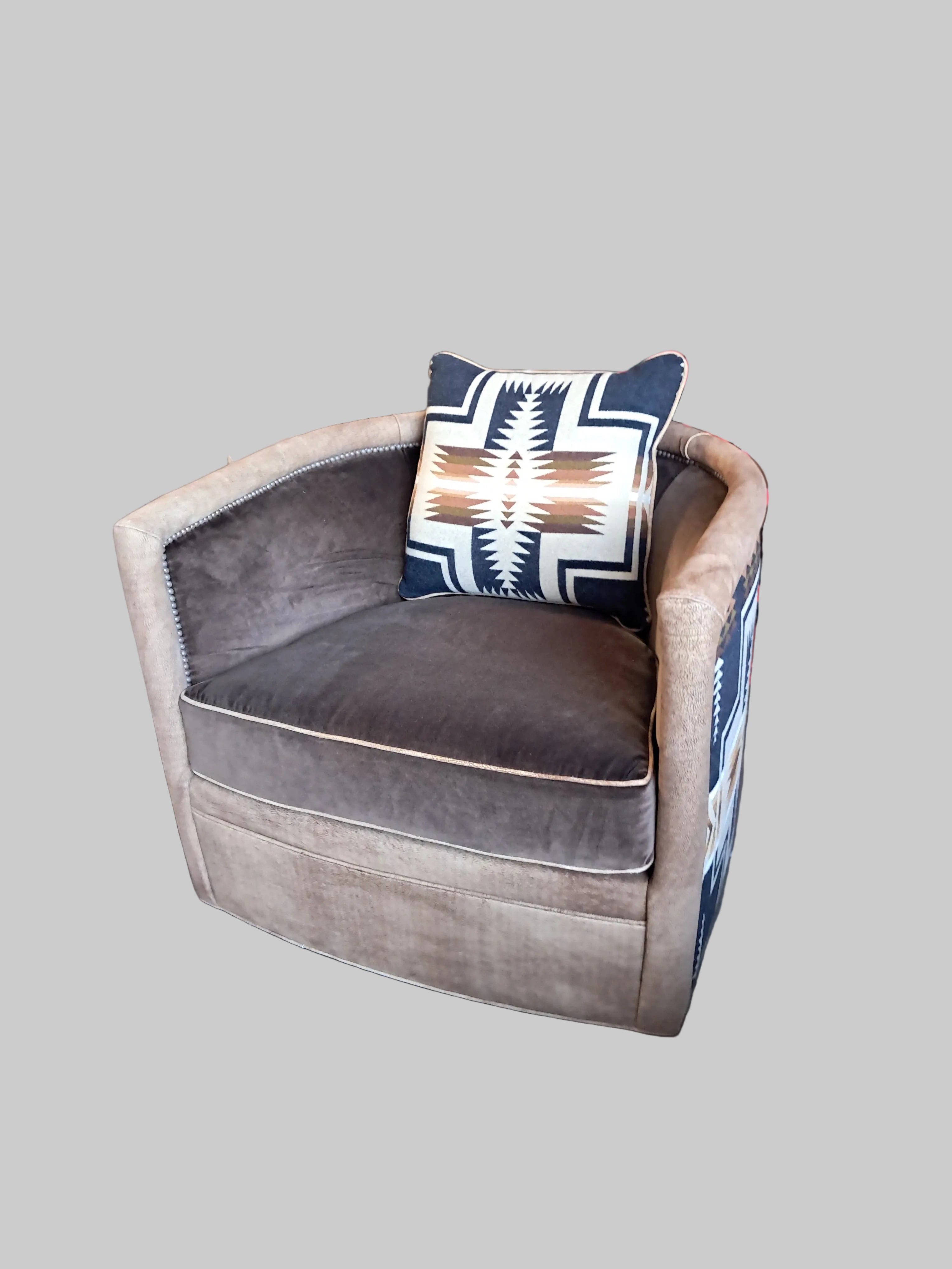 Brown swivel with a patterned pillow on a concrete floor.