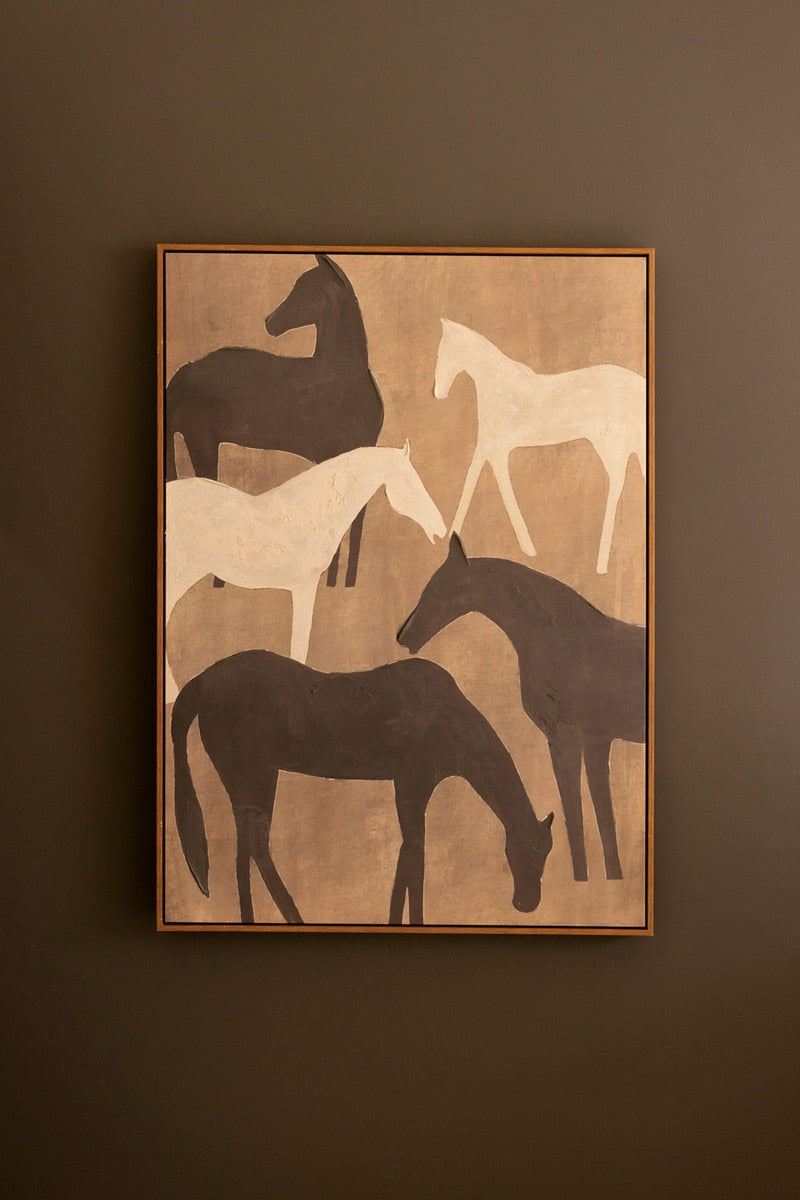 Framed artwork of horses on a brown wall