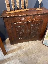 Dark oak two door buffet with geometric and foliate carved door panels
