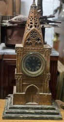 Carved church sculpture with a clock built as a Gothic cathedral facade with a pierced spire