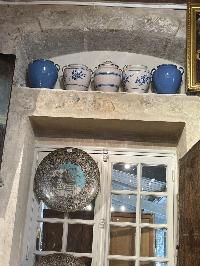 Five blue and white glazed pottery jars in graduated sizes with soft cobalt banding