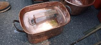 French copper stewpot with a fitted lid and iron side handles in warm rose copper