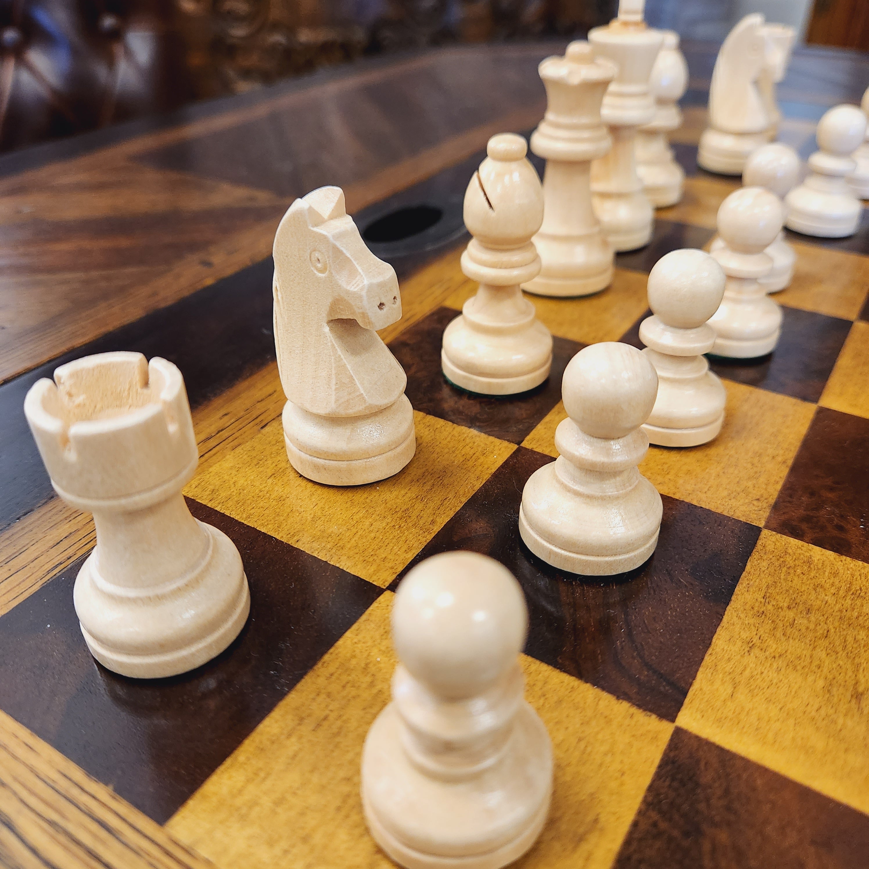 White chess pieces on a wooden chessboard