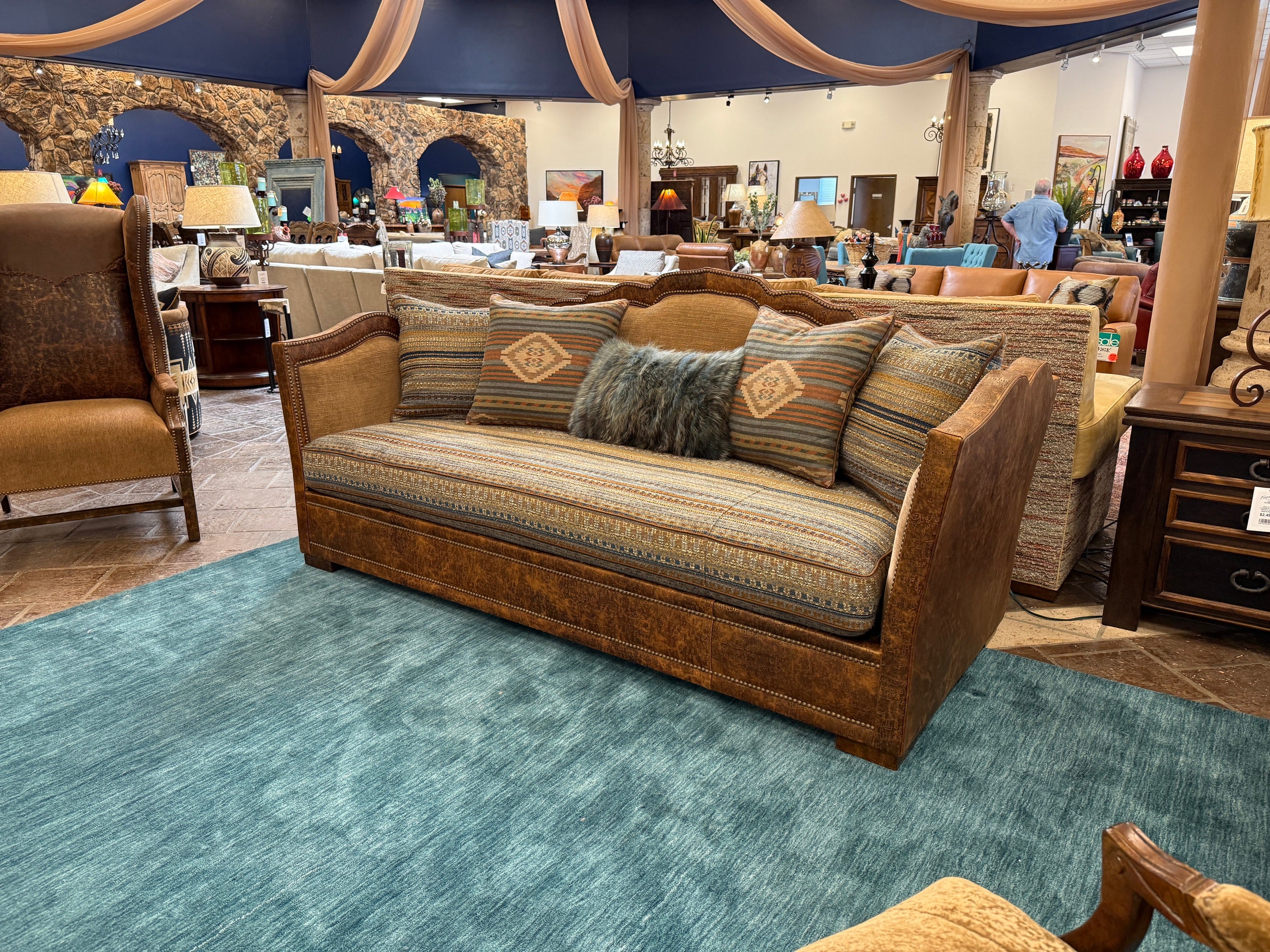 Decorative sofa with patterned cushions in a showroom setting