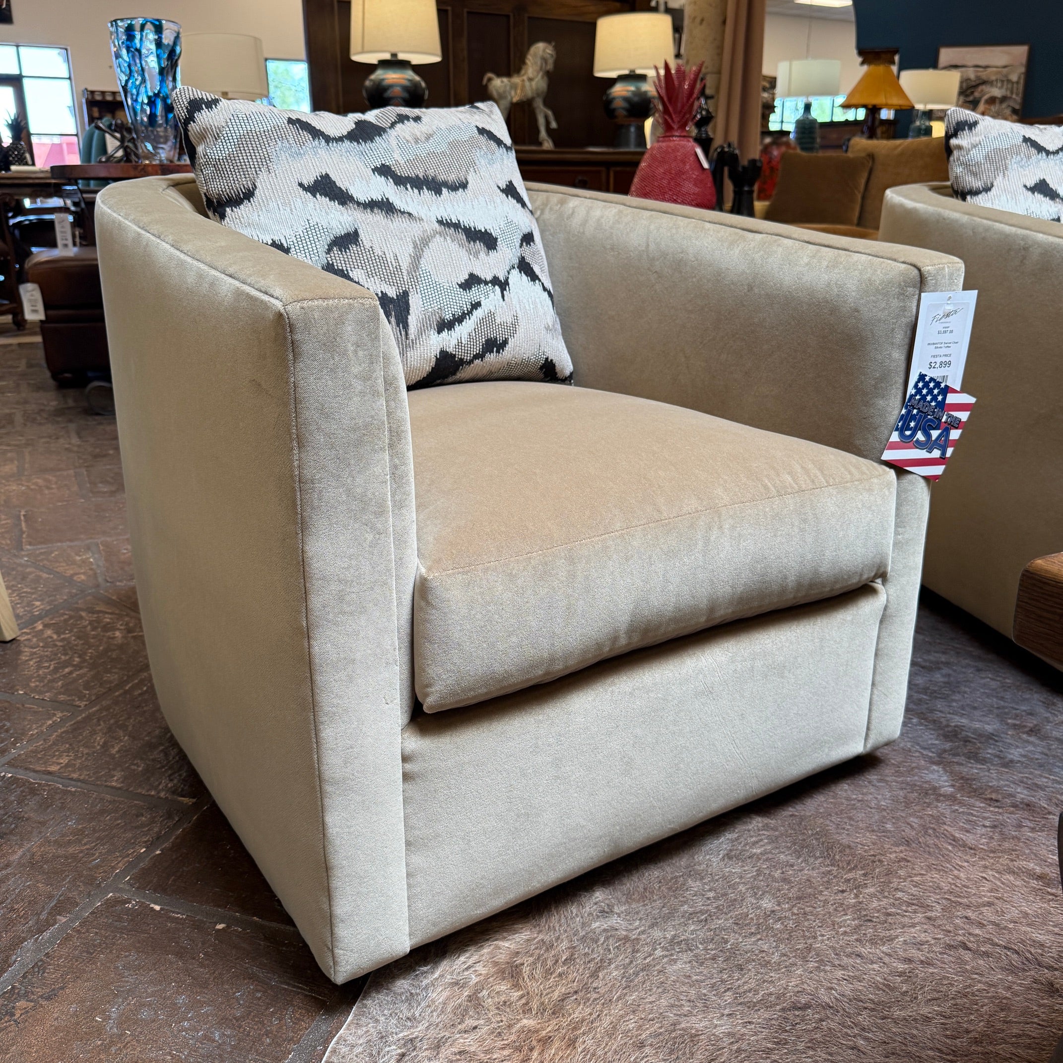 Beige armchair with a patterned pillow in a showroom setting