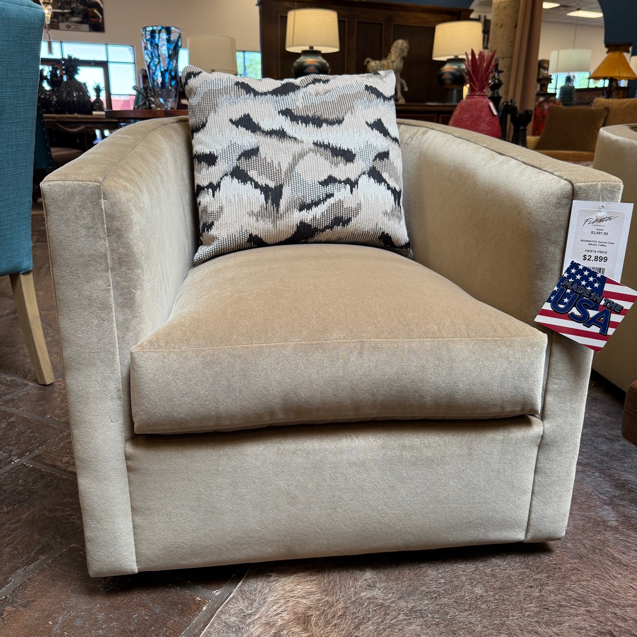 Beige armchair with a patterned pillow and price tag in a store setting