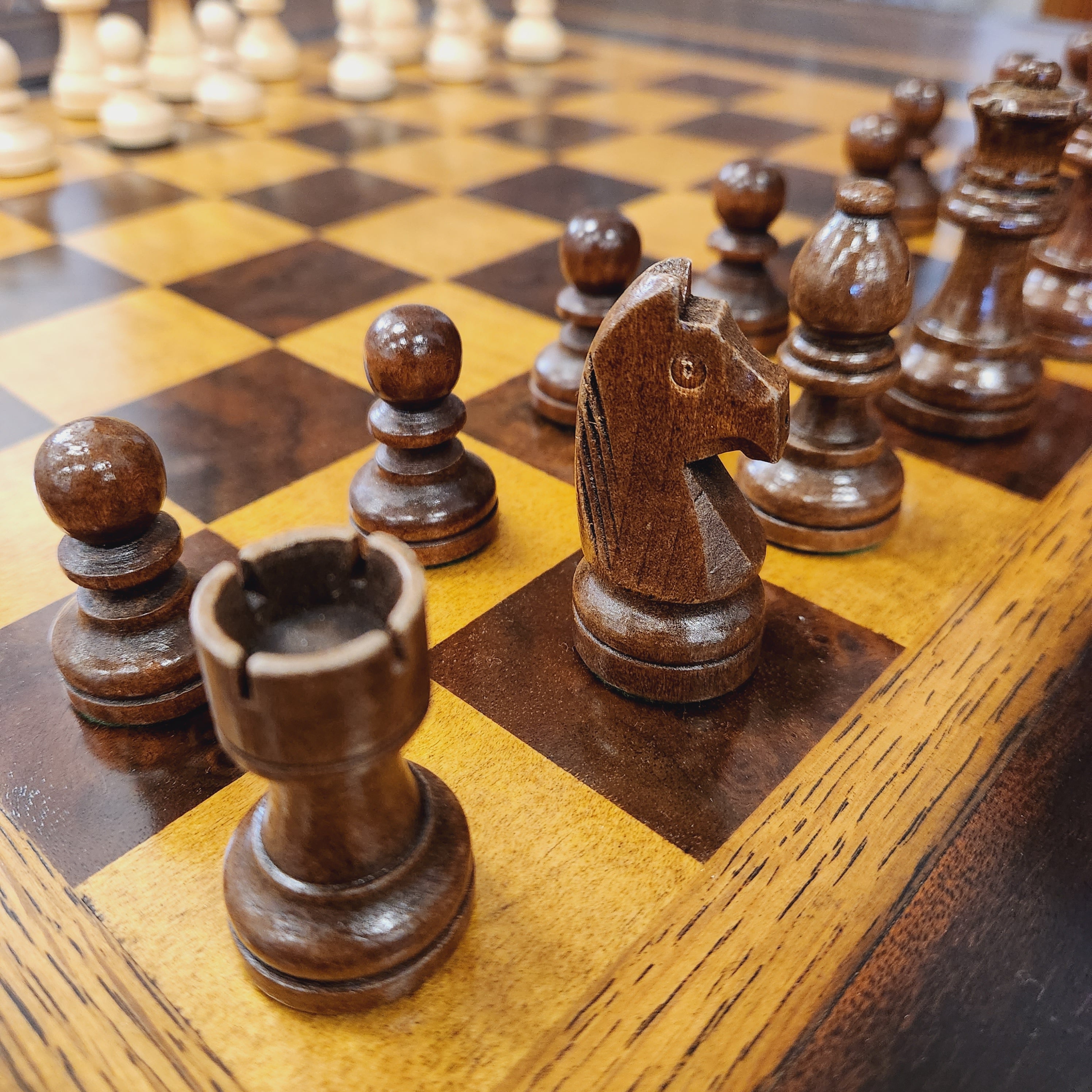 Close-up of wooden chess pieces on a checkered wooden board
