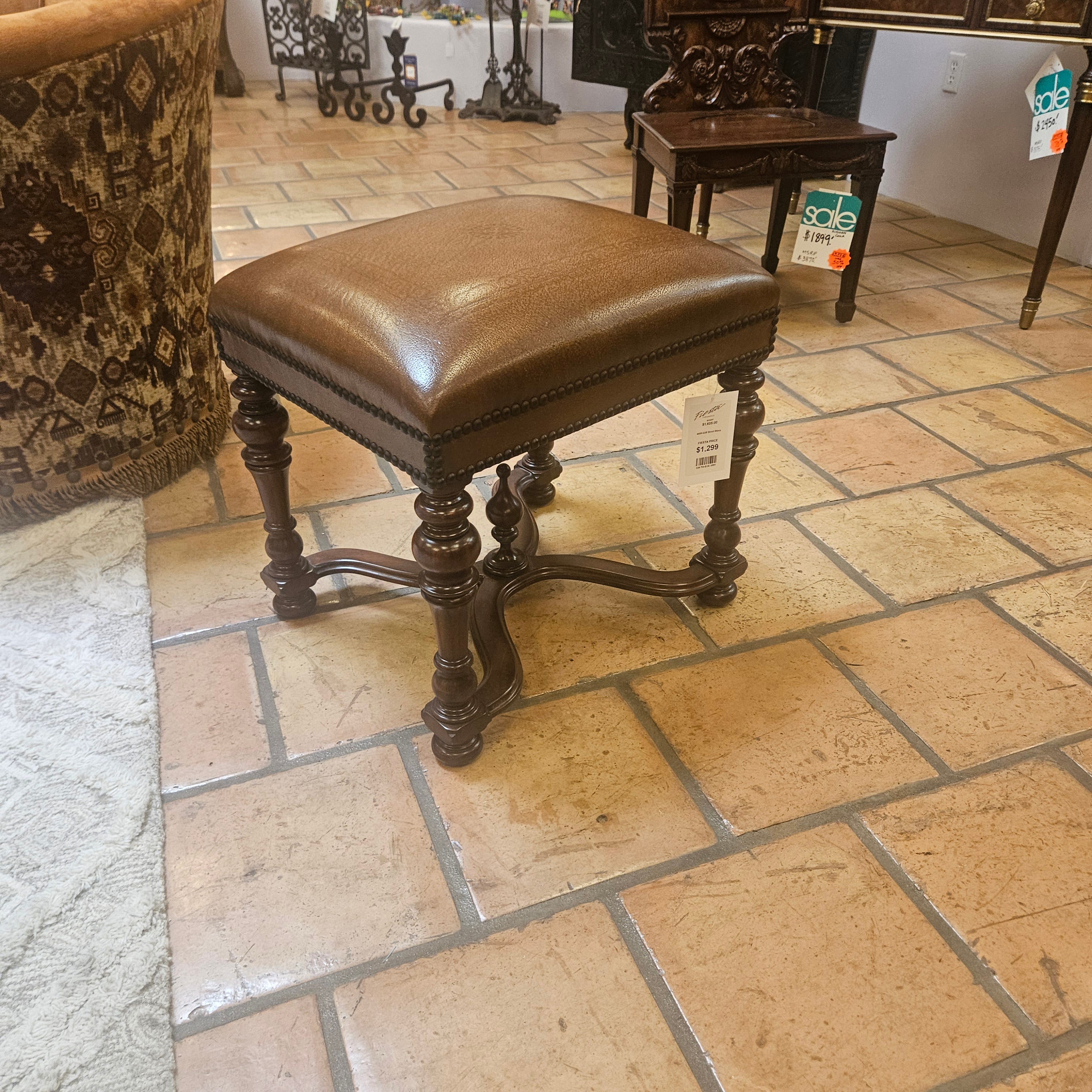 Brown leather chair with metal legs on a tiled floor