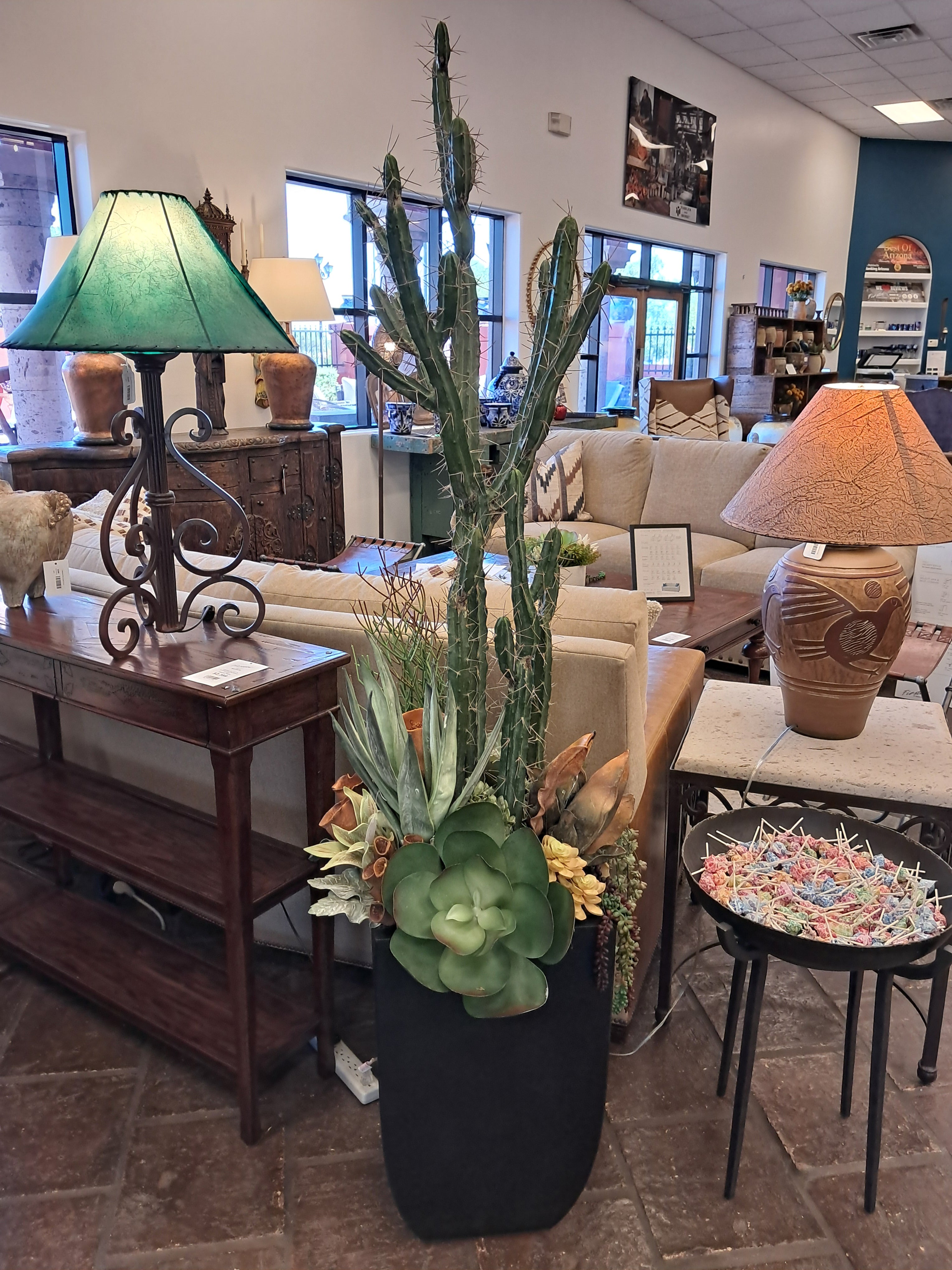 Living room with a cactus plant, lamp, and decorative items on a table.