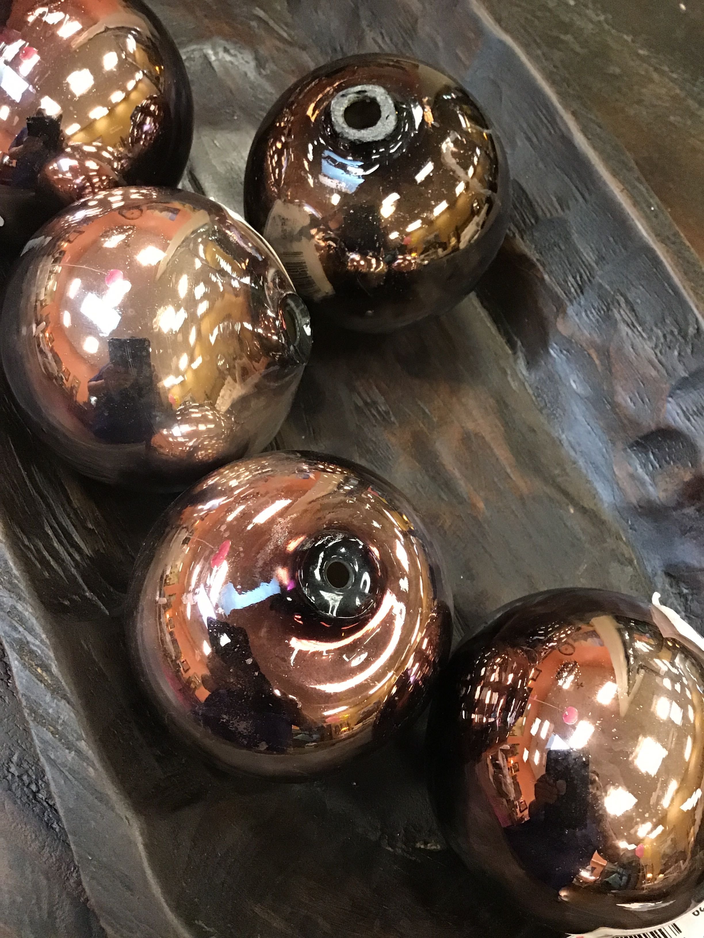 Bronze-colored spherical objects on a reflective surface