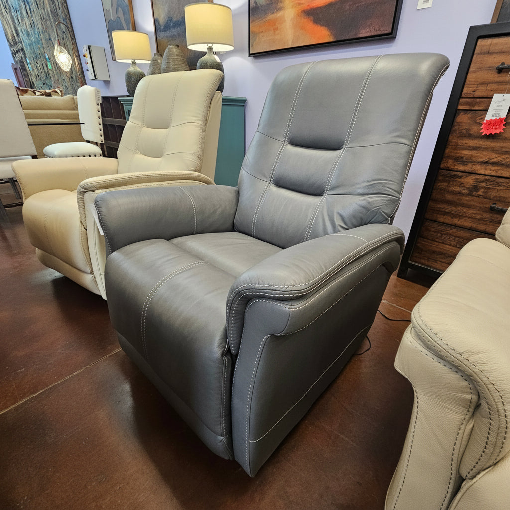 Gray recliner chair with a 'sale' tag in a furniture store setting