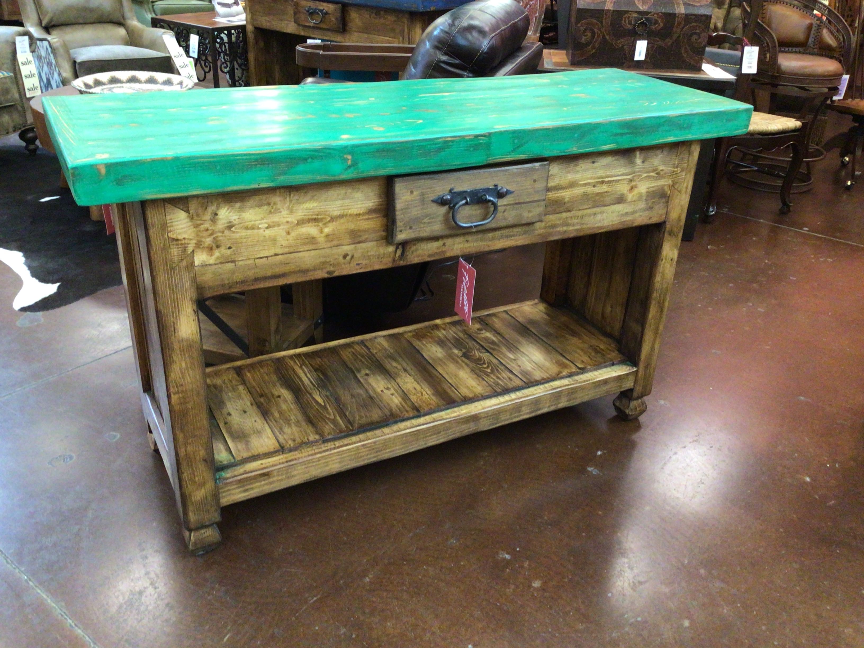 Wooden kitchen island with green top in a store setting