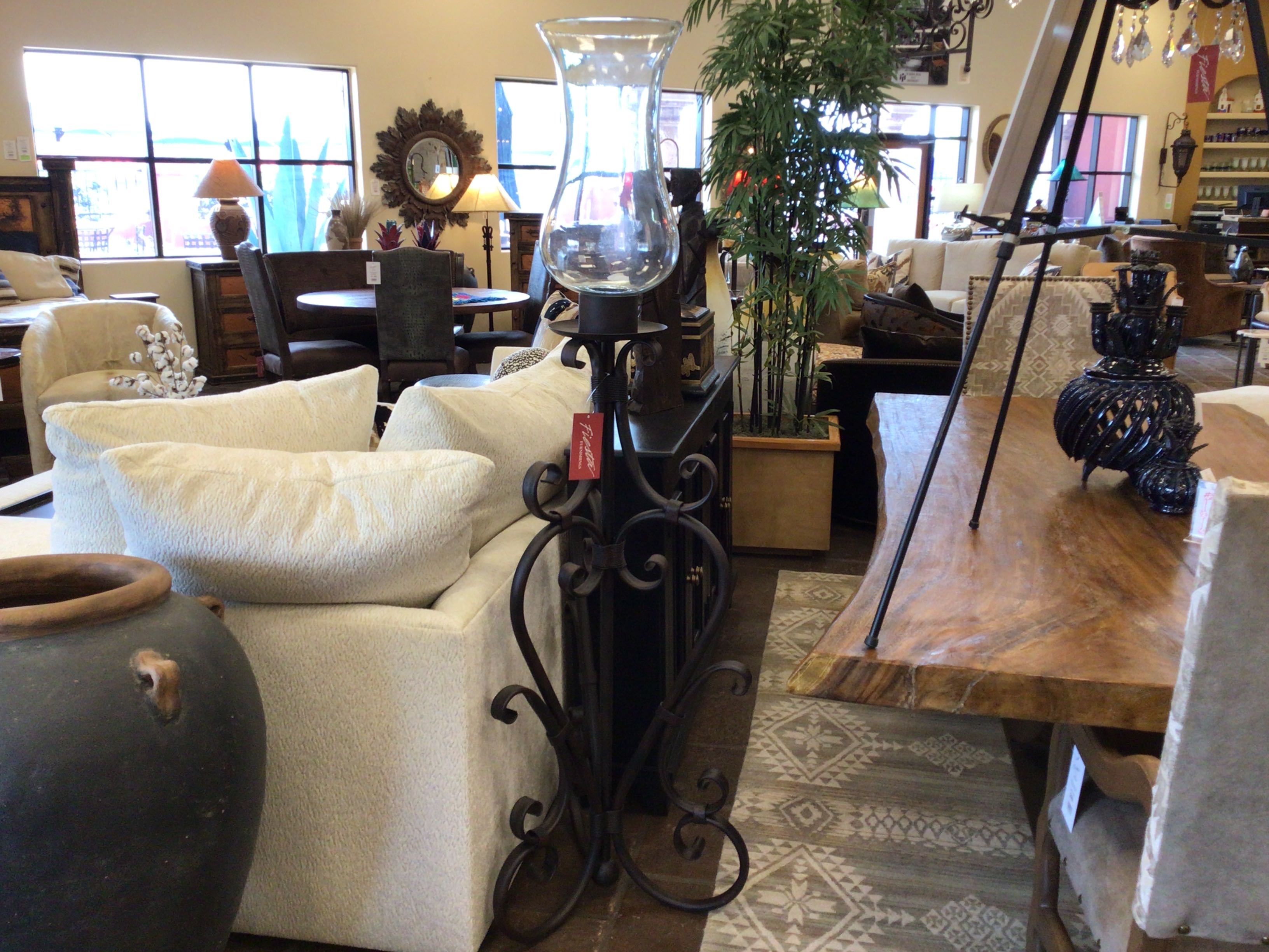 Furniture store interior with various pieces of furniture including a white sofa, wooden table, and decorative items.