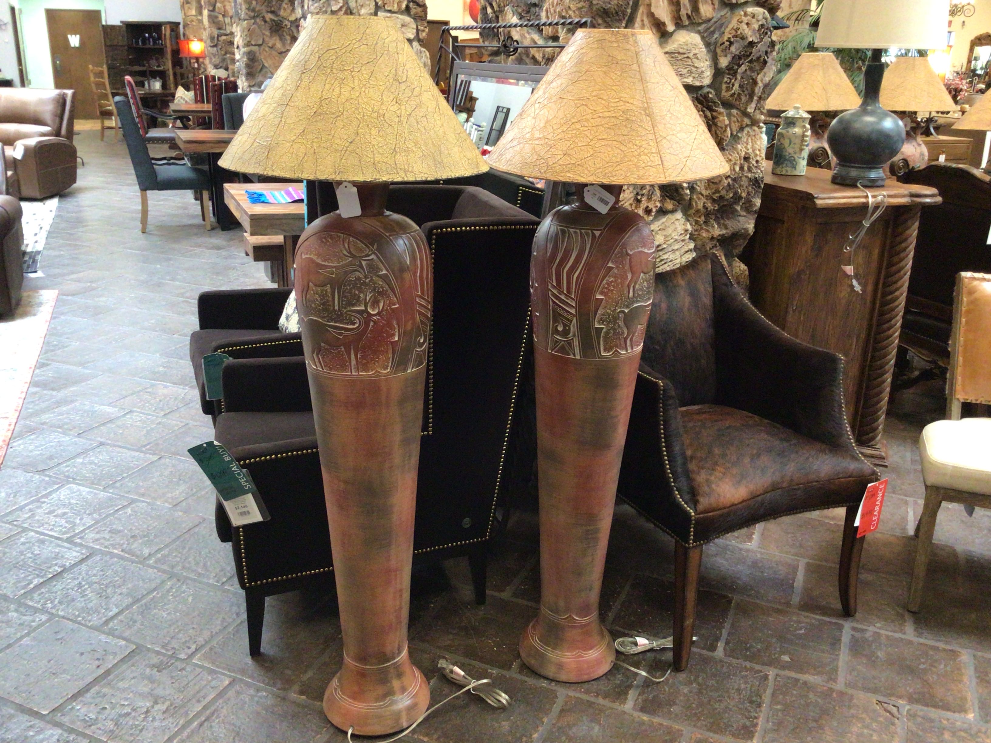Two tall, decorative lamps with lampshades in a store setting.