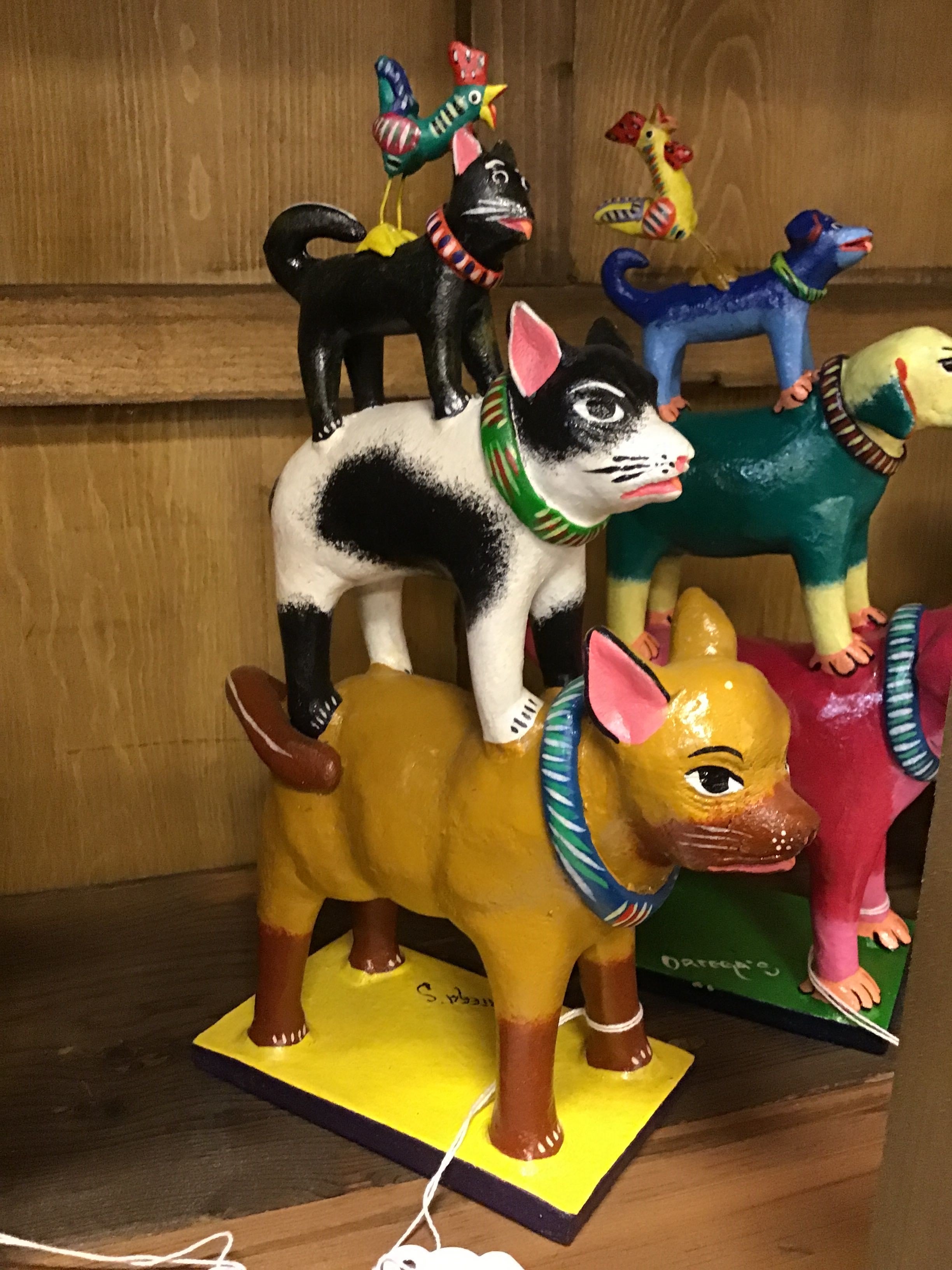 Colorful dog figurines stacked on top of each other with a wooden background