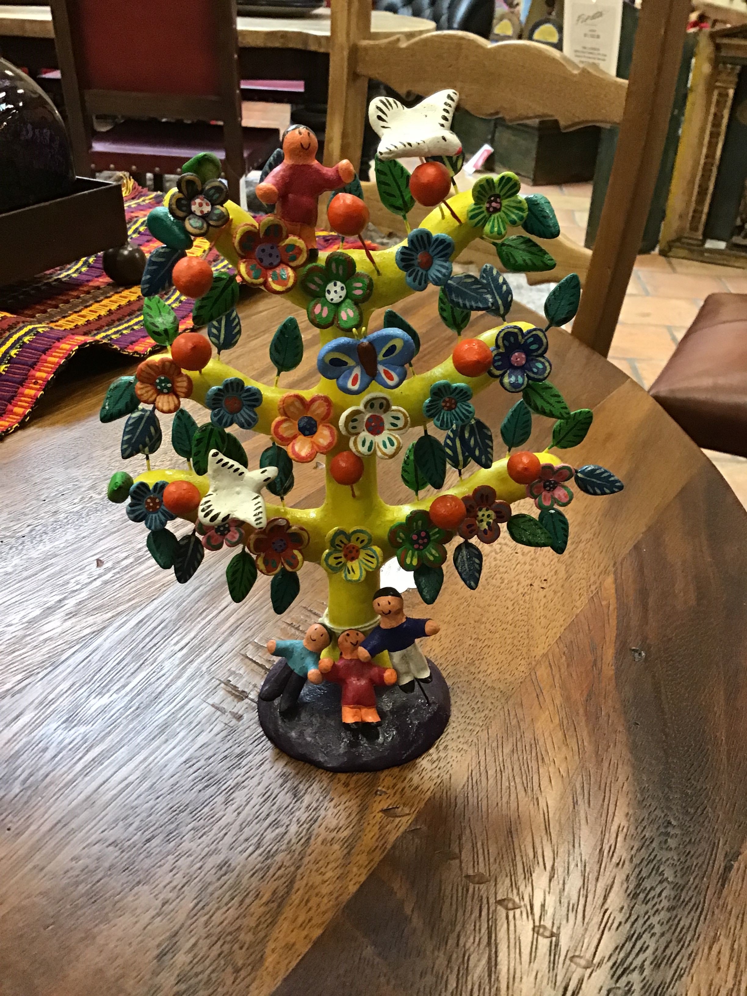 Colorful tree figurine with people and animals on a wooden table