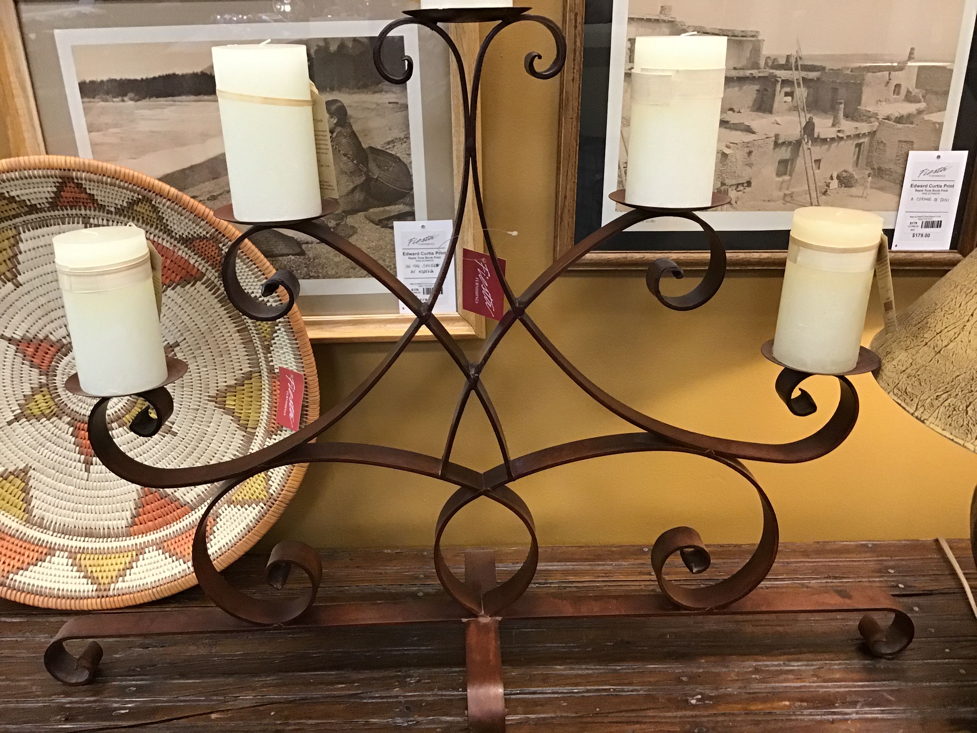 Decorative metal candle holder with candles on a wooden surface, with a blurred background.
