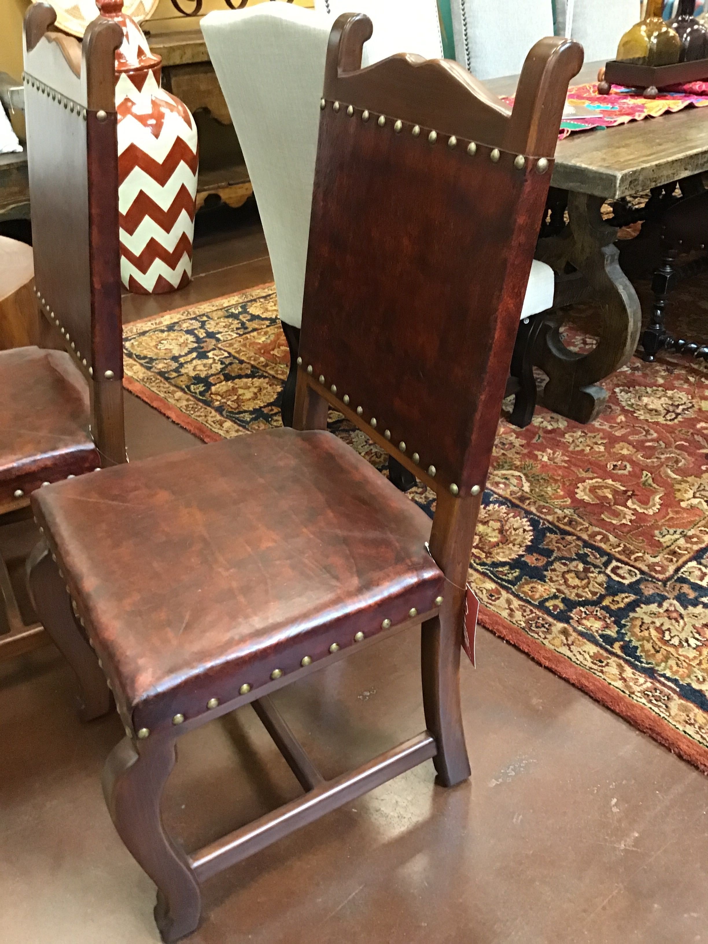 Brown leather chair with wooden frame on a patterned rug
