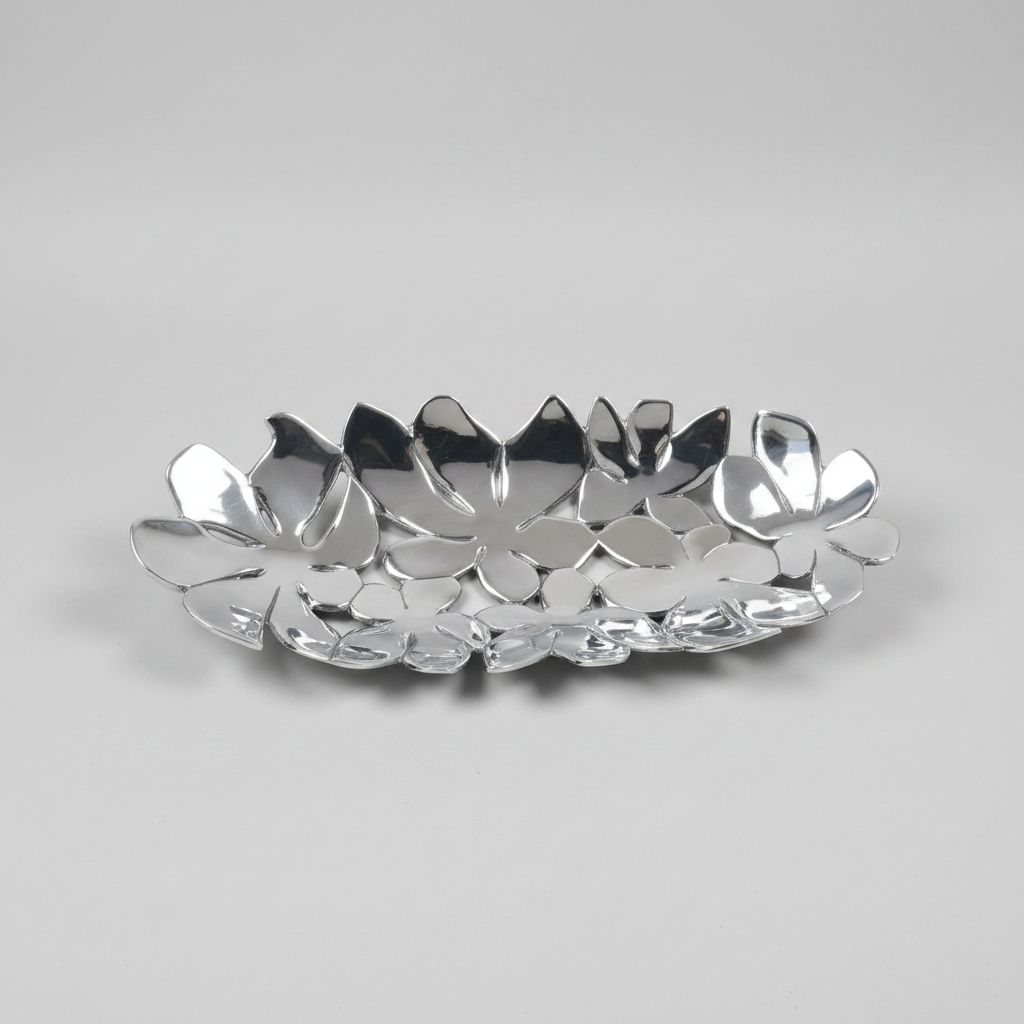 A polished silver metal decorative tray with a layered, flower-like petal design, photographed on a neutral light gray background.