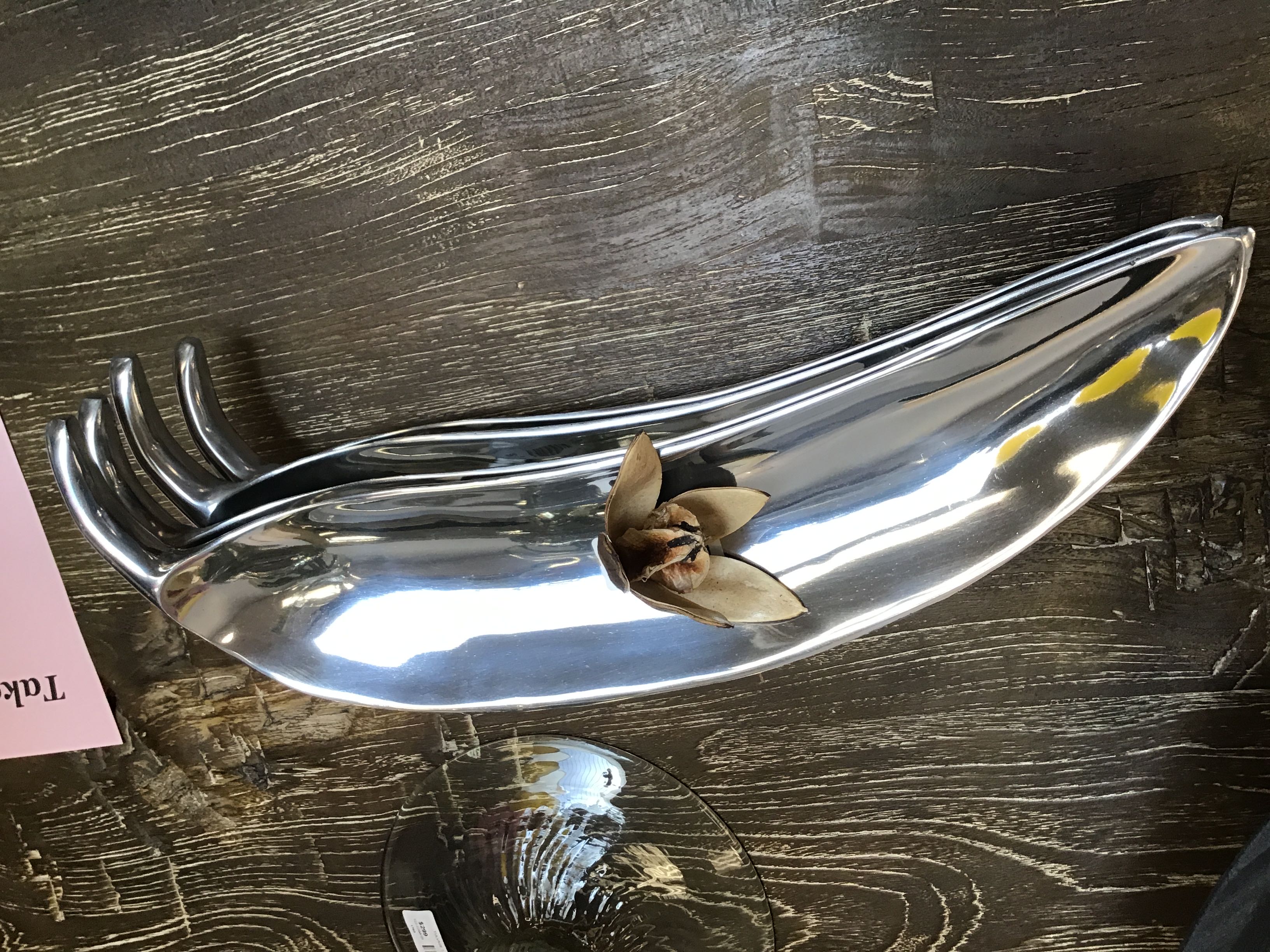 Metallic spoon-shaped object on a wooden surface