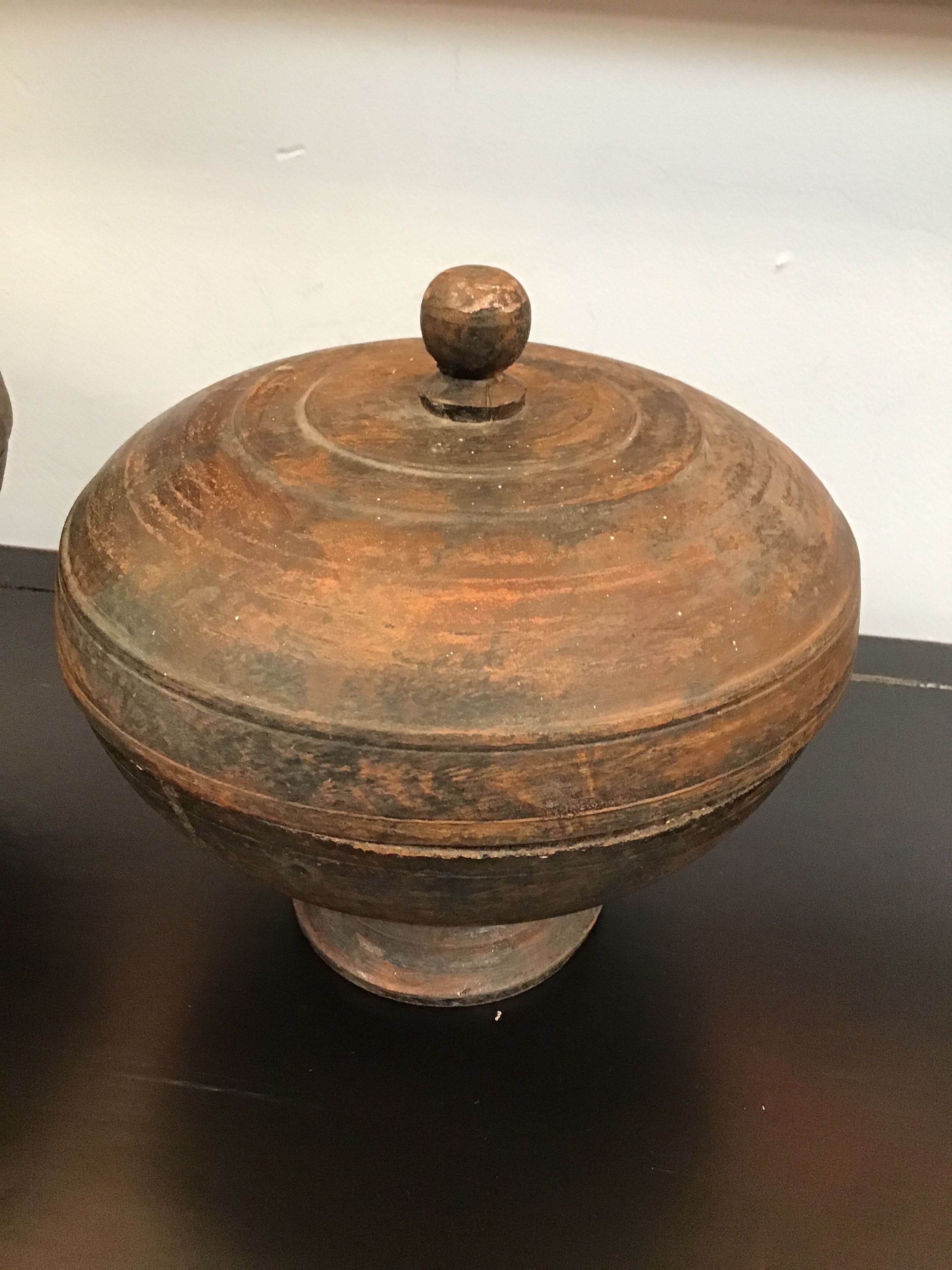 Wooden bowl with a lid on a dark surface