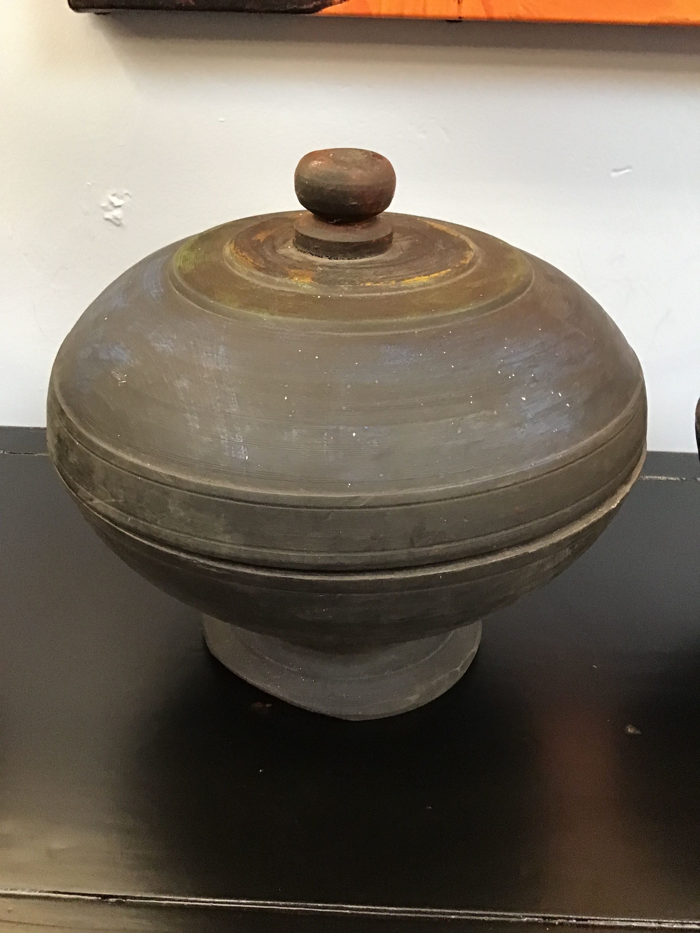 Vintage ceramic pot with lid on a black surface