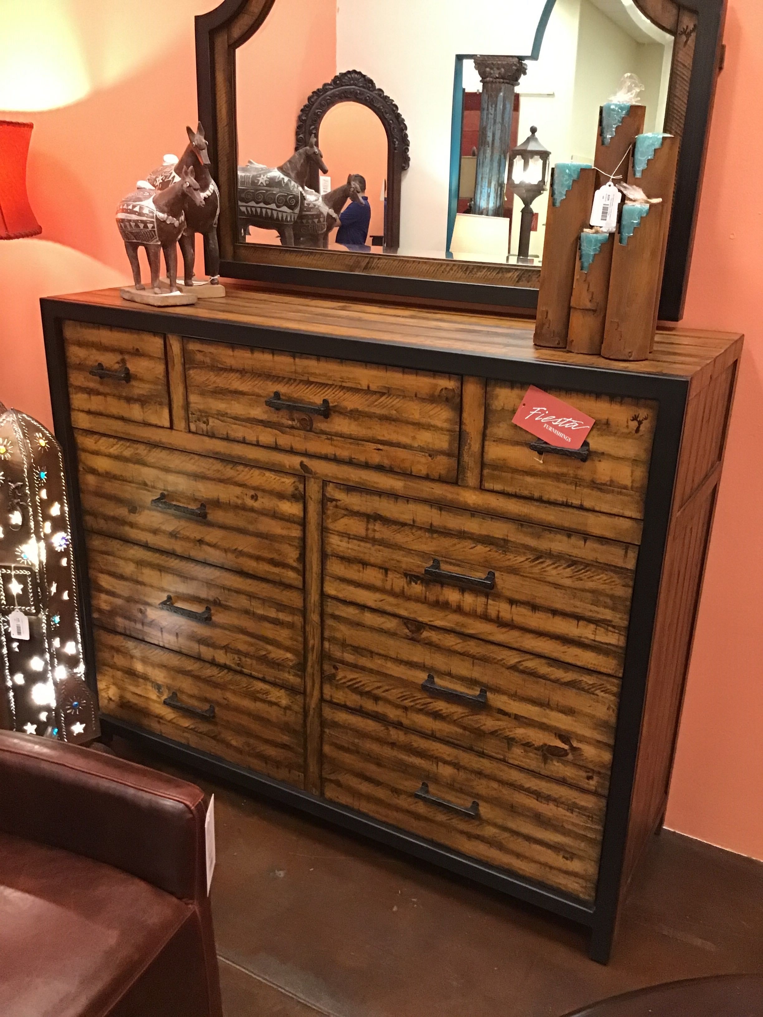 Wooden dresser with mirror on a peach-colored wall