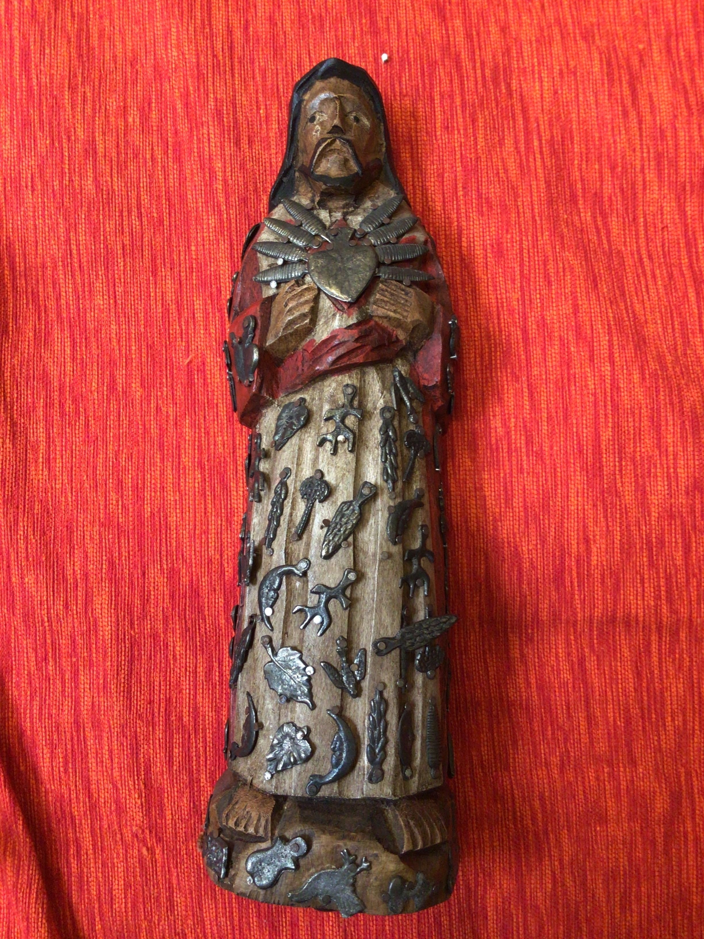 Wooden figurine with decorative elements on a red background