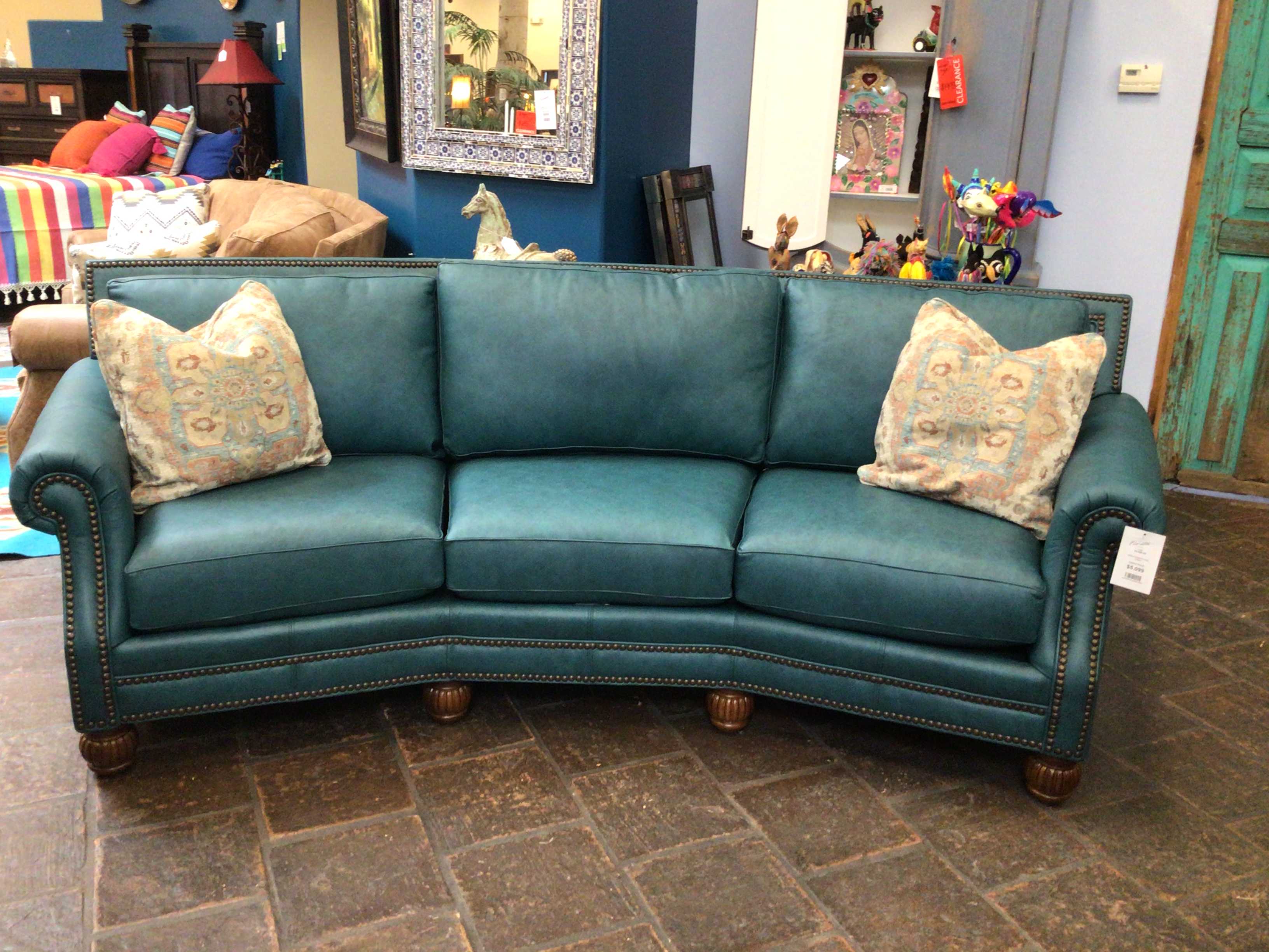 Teal sectional sofa with decorative pillows in a store setting